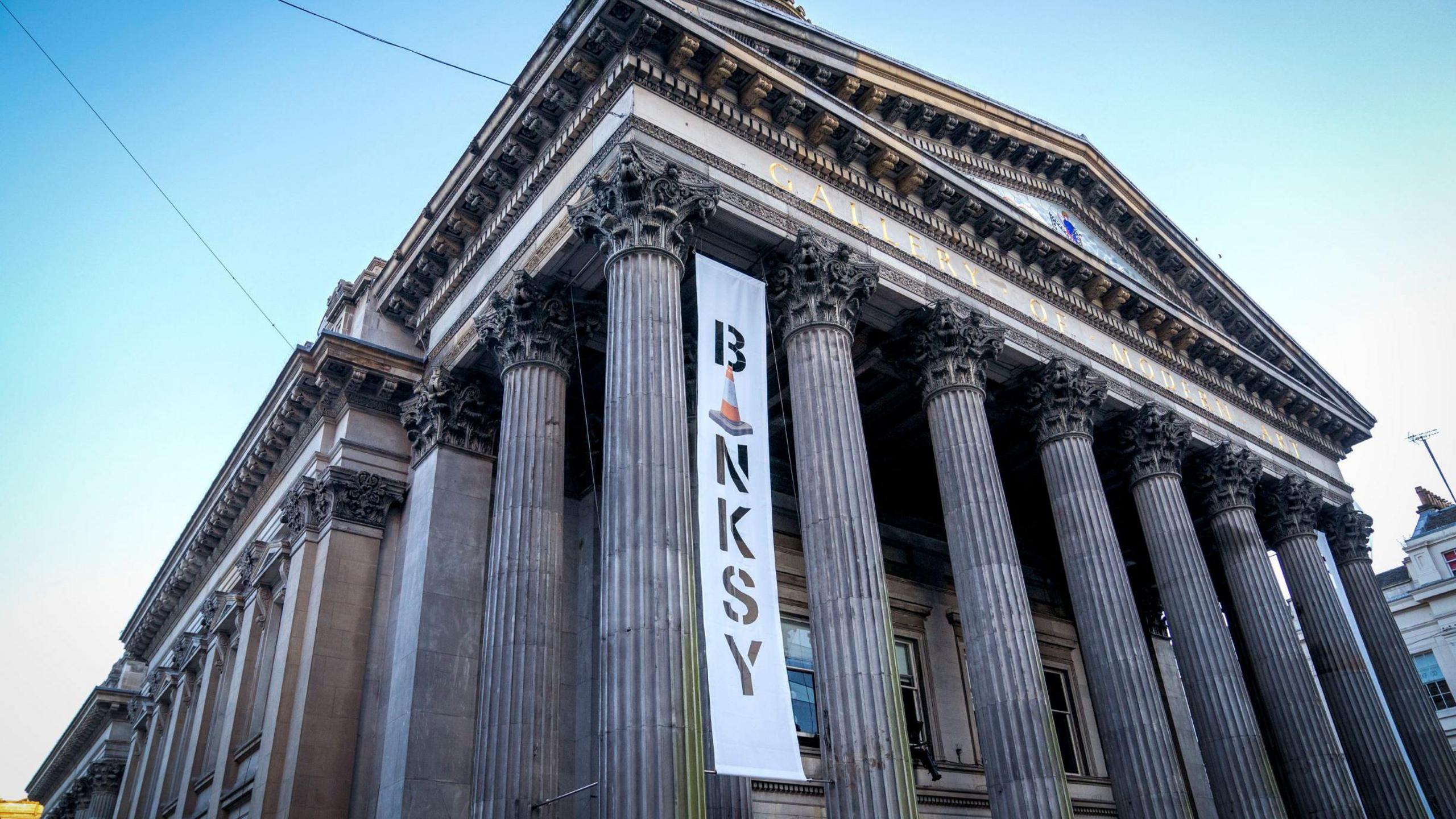 The Gallery of Modern Art in Glasgow, with a banner advertising the Banksy exhibition held there 