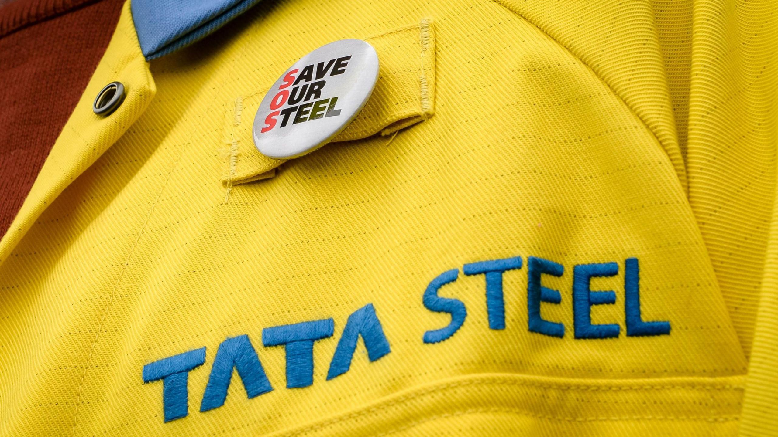 Tata Steel worker uniform with a "Save Our Steel " badge on it