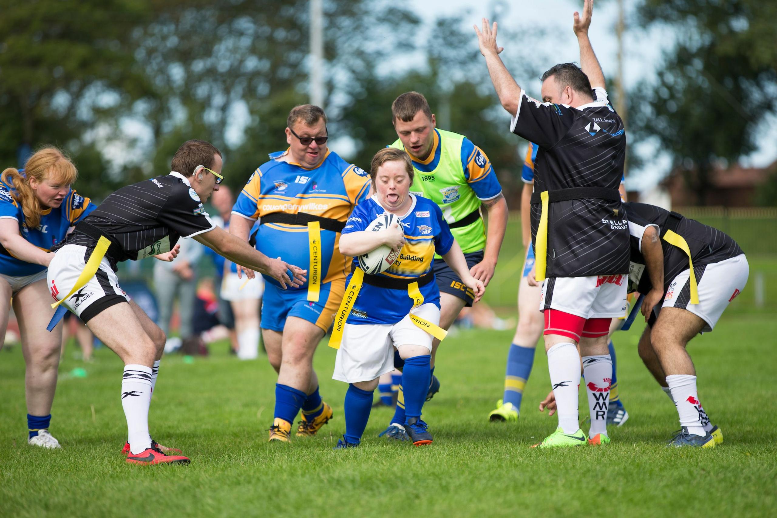 Players for Widnes look to tackle a Leeds ball carrier during a game of Learning Disability Rugby League at a festival in Blackpool.