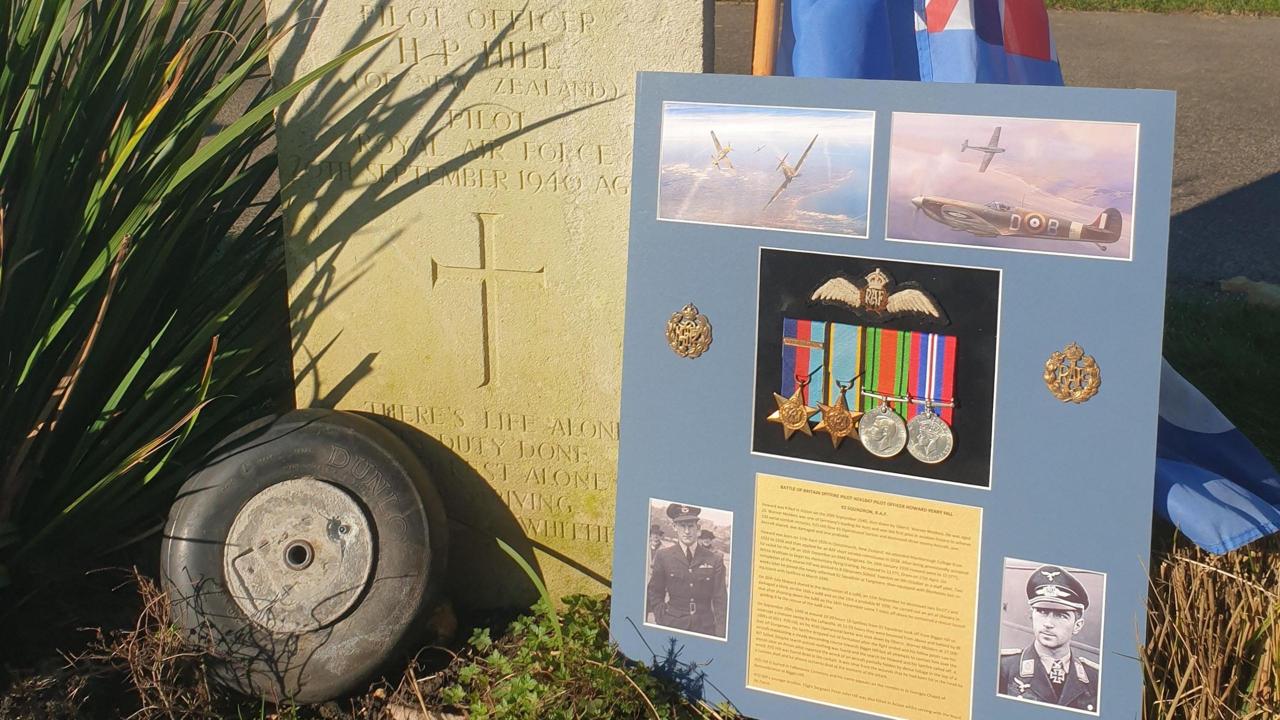 A medal set placed on a board is resting against the grave stone of a New Zealand pilot who died in the Battle of Britain.