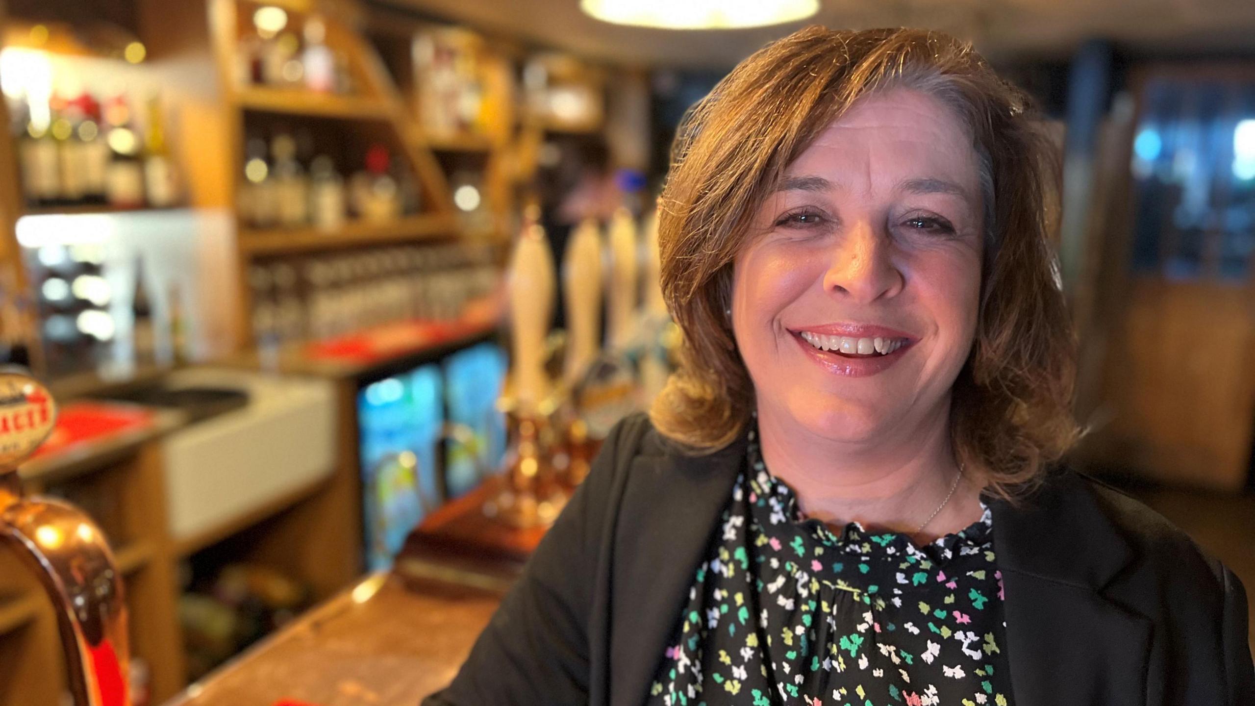 Jacqui Bartels smiling near a pub bar