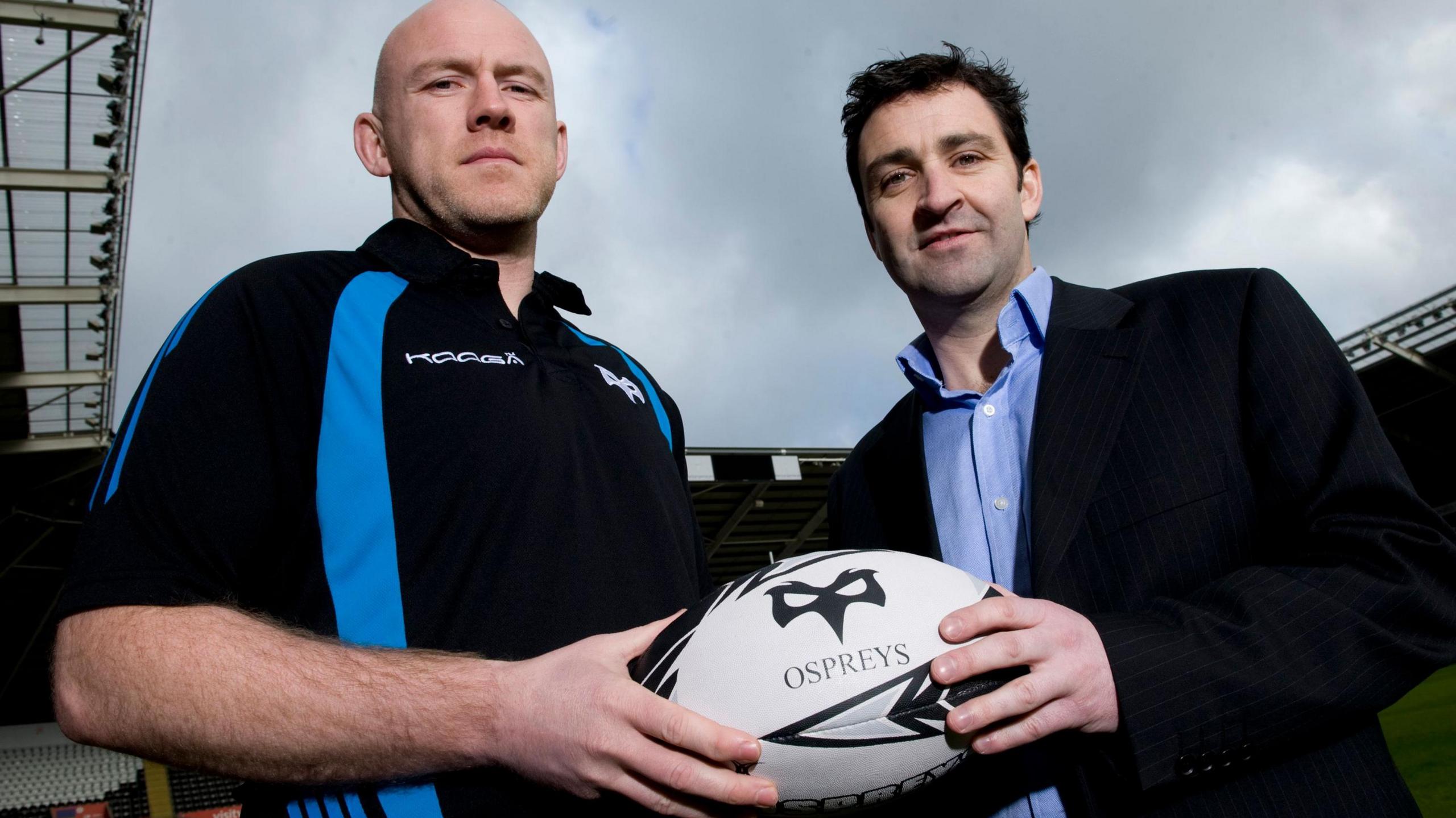 Steve Tandy and Andrew Hore holding a rugby ball in 2012