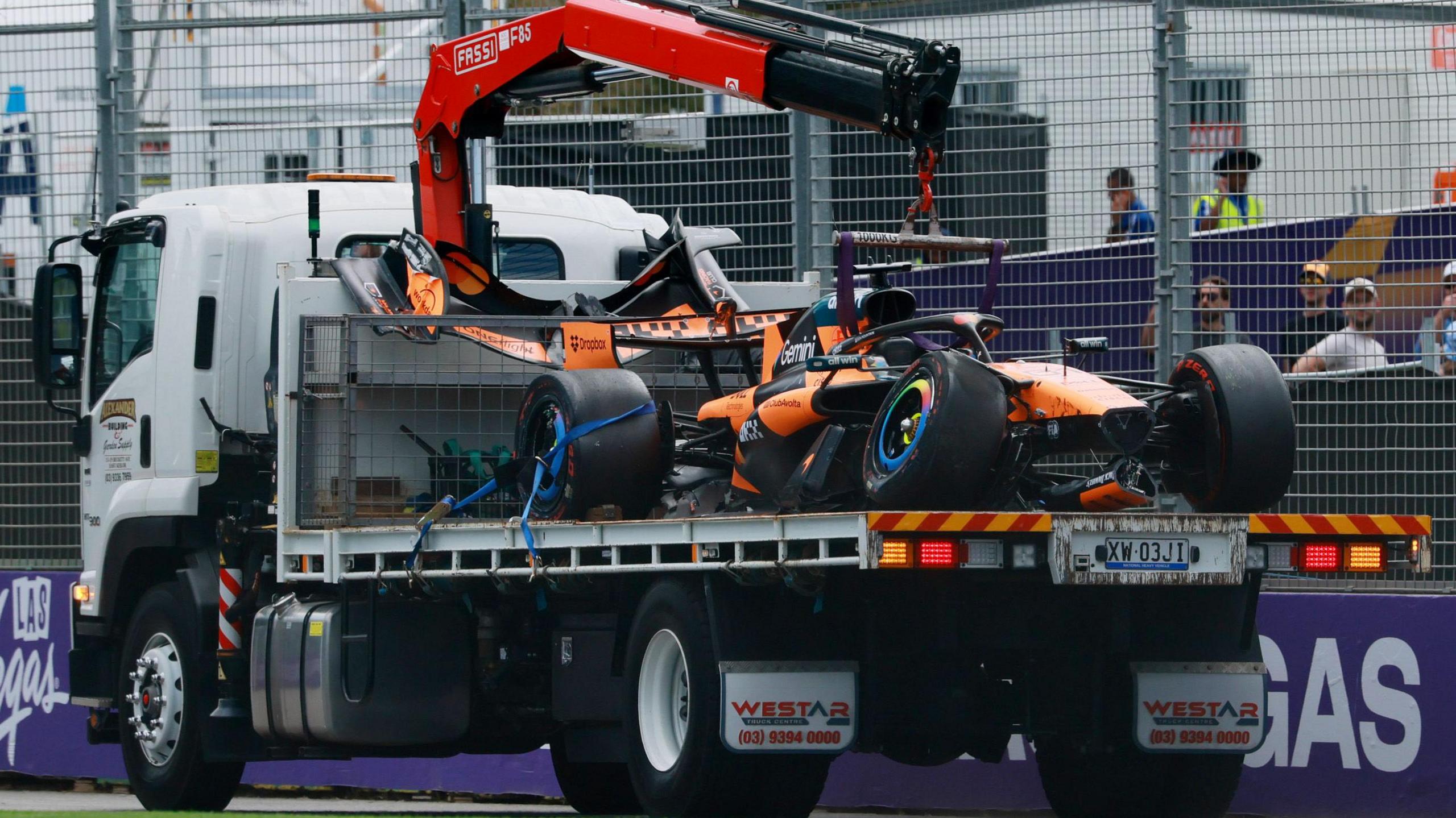 The damaged McLaren of Oscar Piastri is driven away on a truck after he crashed on the way to the grid before the Australian Grand Prix
