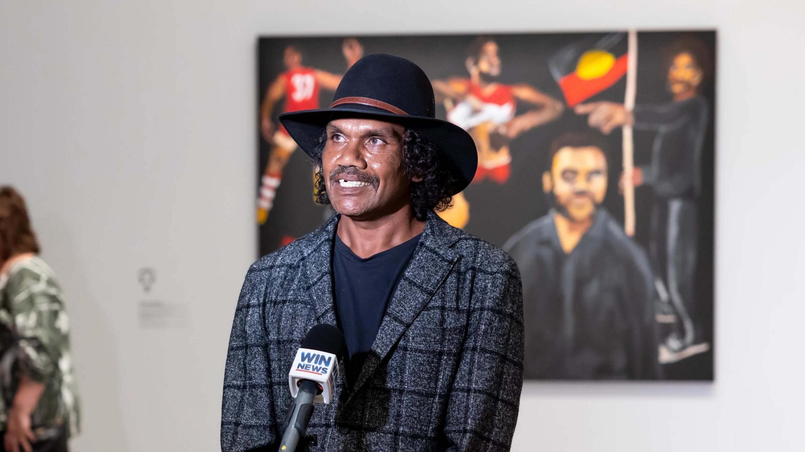 Vincent Namatjira with his award-winning portrait of Adam Goodes