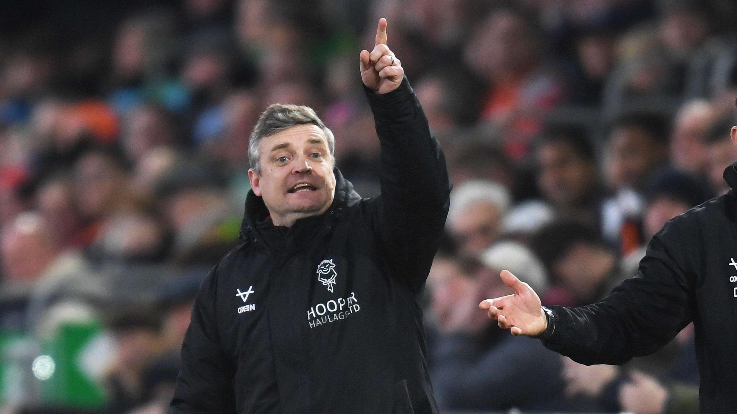 Lincoln City boss Michael Skubala points and shouts instructions to his players