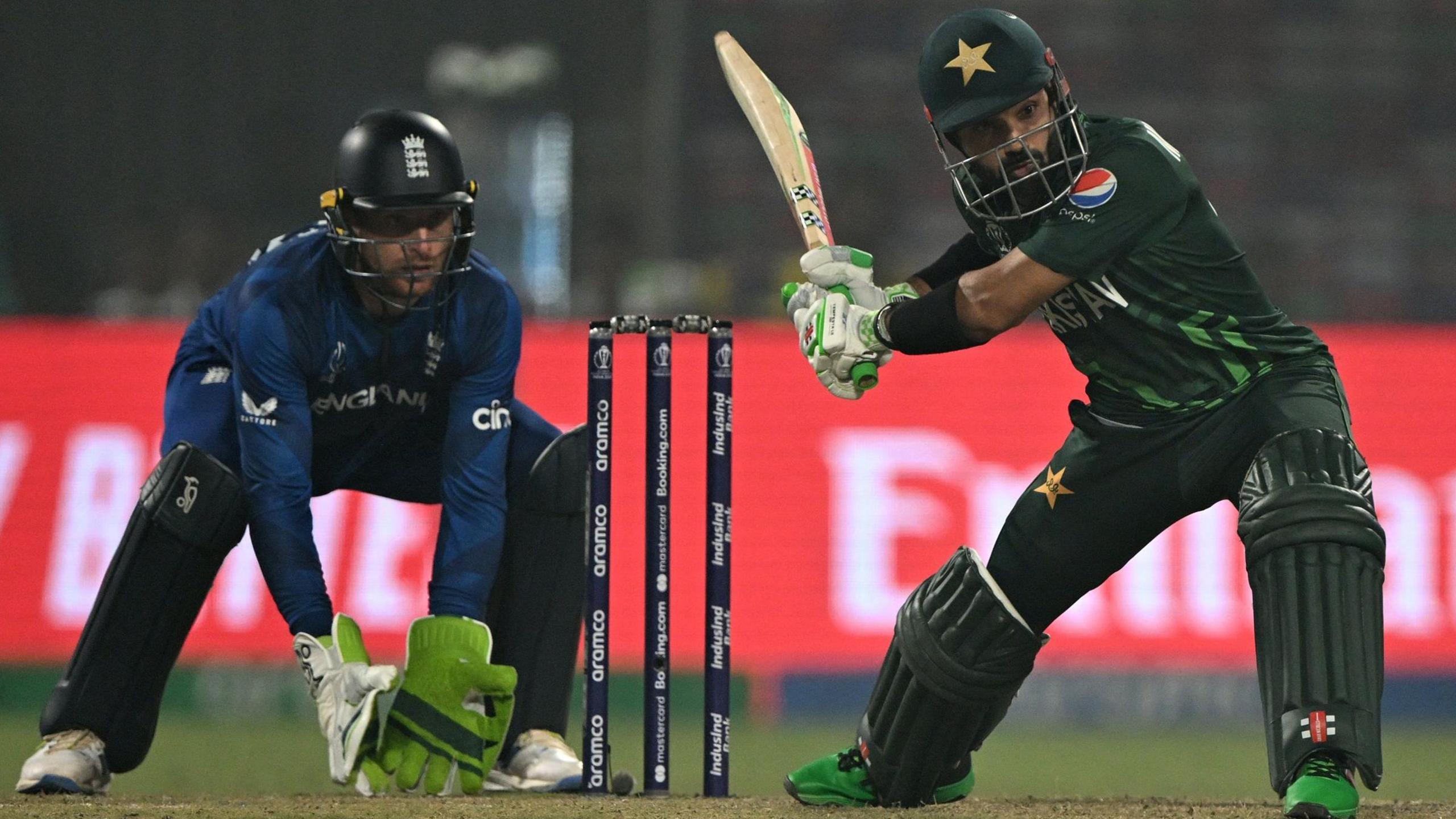 Pakistan's Mohammad Rizwan hits out, watched by England wicketkeeper Jos Buttler, in a World Cup match in 2023
