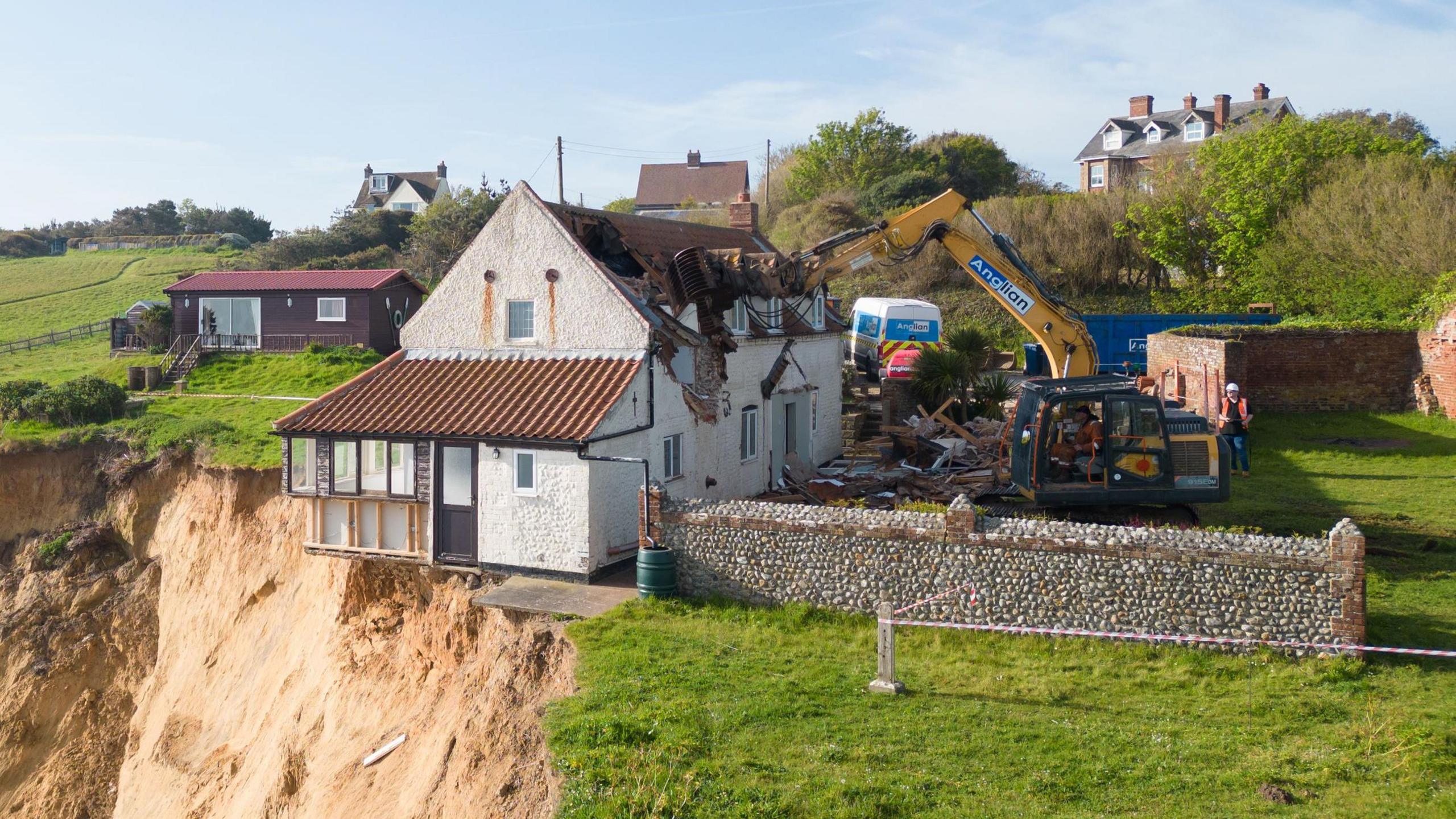 Plant destroying a farmhouse overhanging a cliff