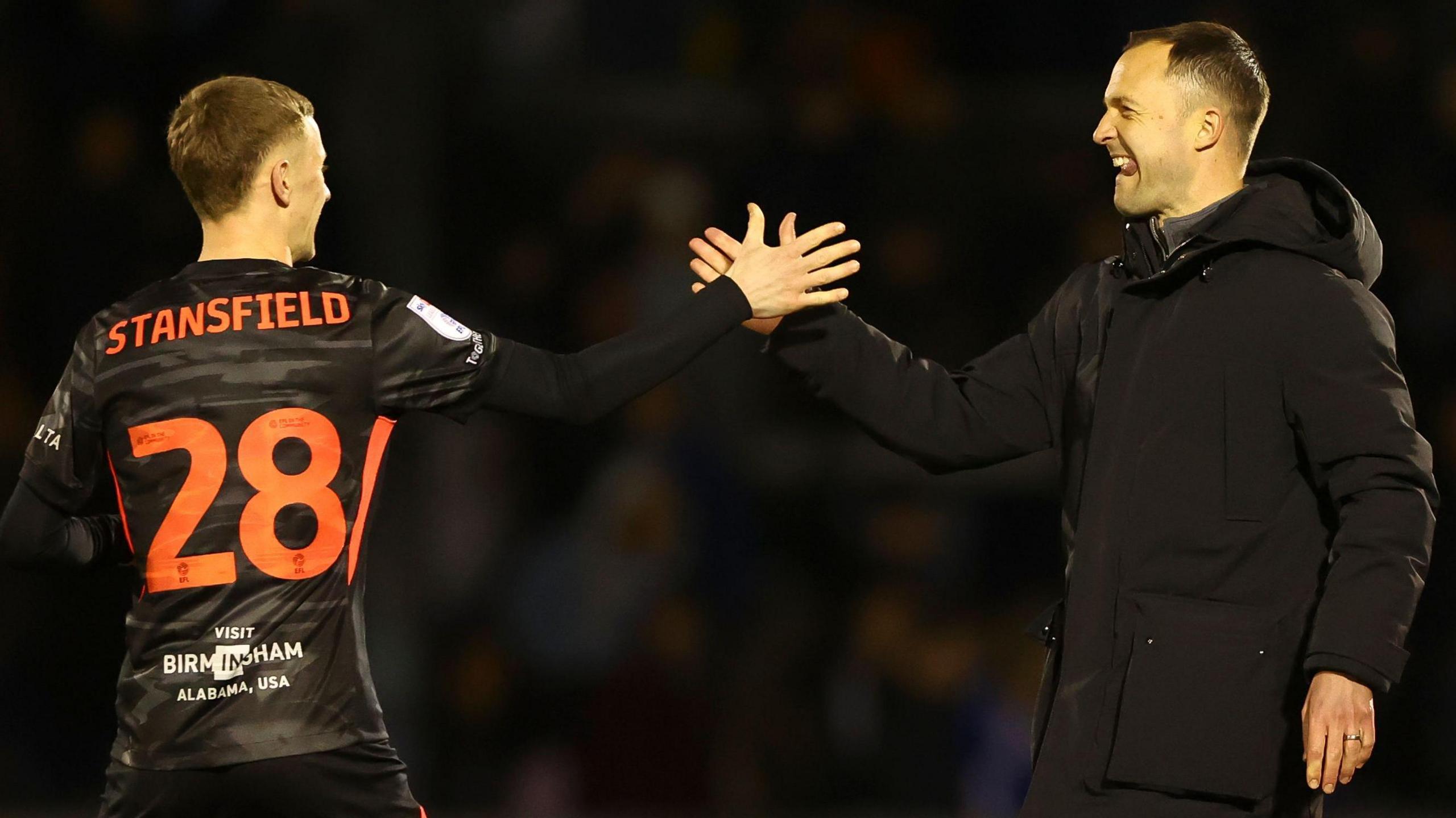 Birmingham City striker Jay Stansfield on the left gives a high five to manager Chris Davies after a game