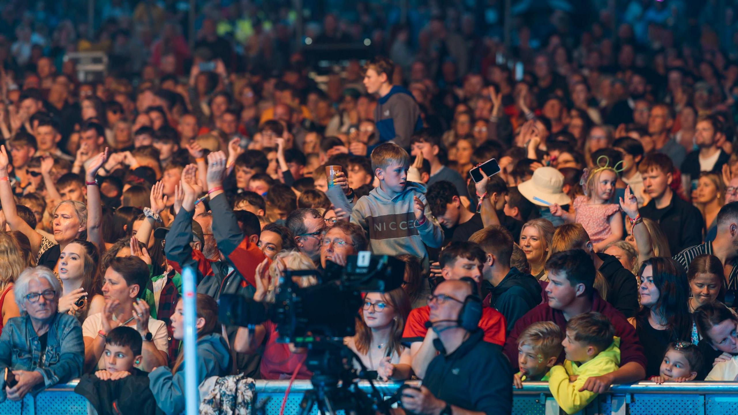 A large crowd of people of all ages in front of the stage