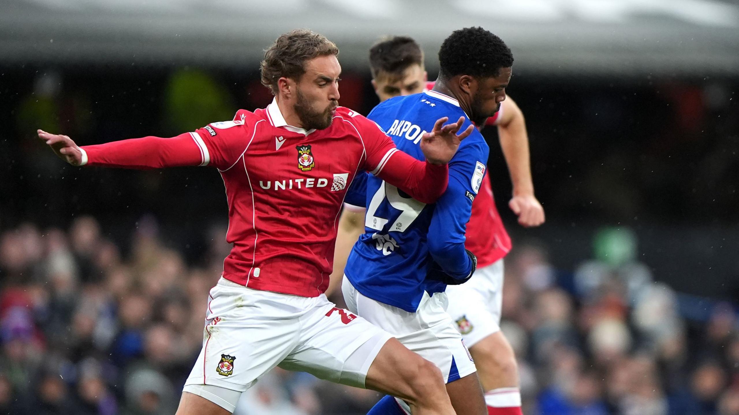 Wrexham's Sam Smith (left) and Ipswich Town's Chuba Akpom battle for the ball