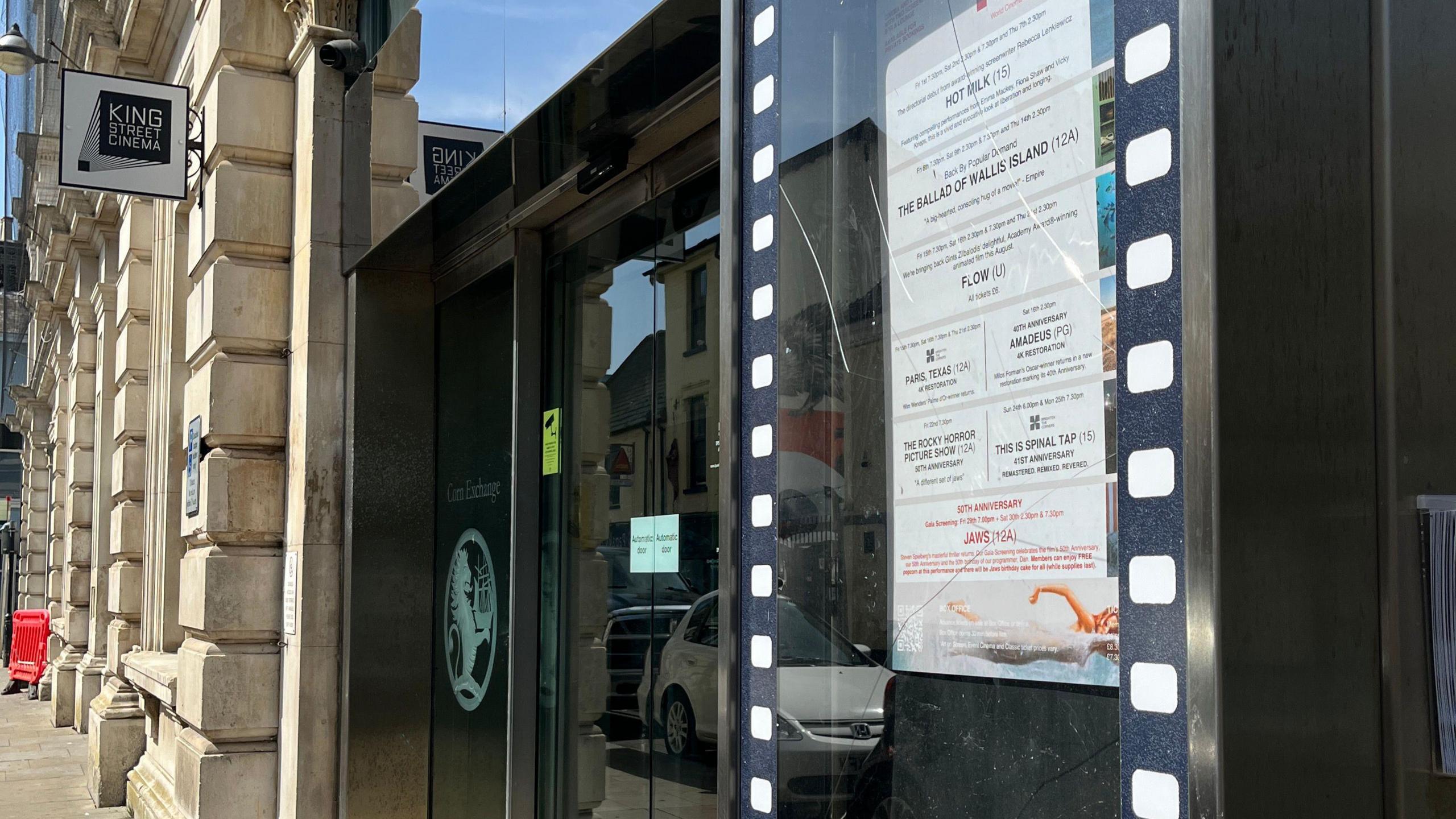 The entrance into King Street Cinema. A poster detailing films and timings is stuck on the inside of the window.