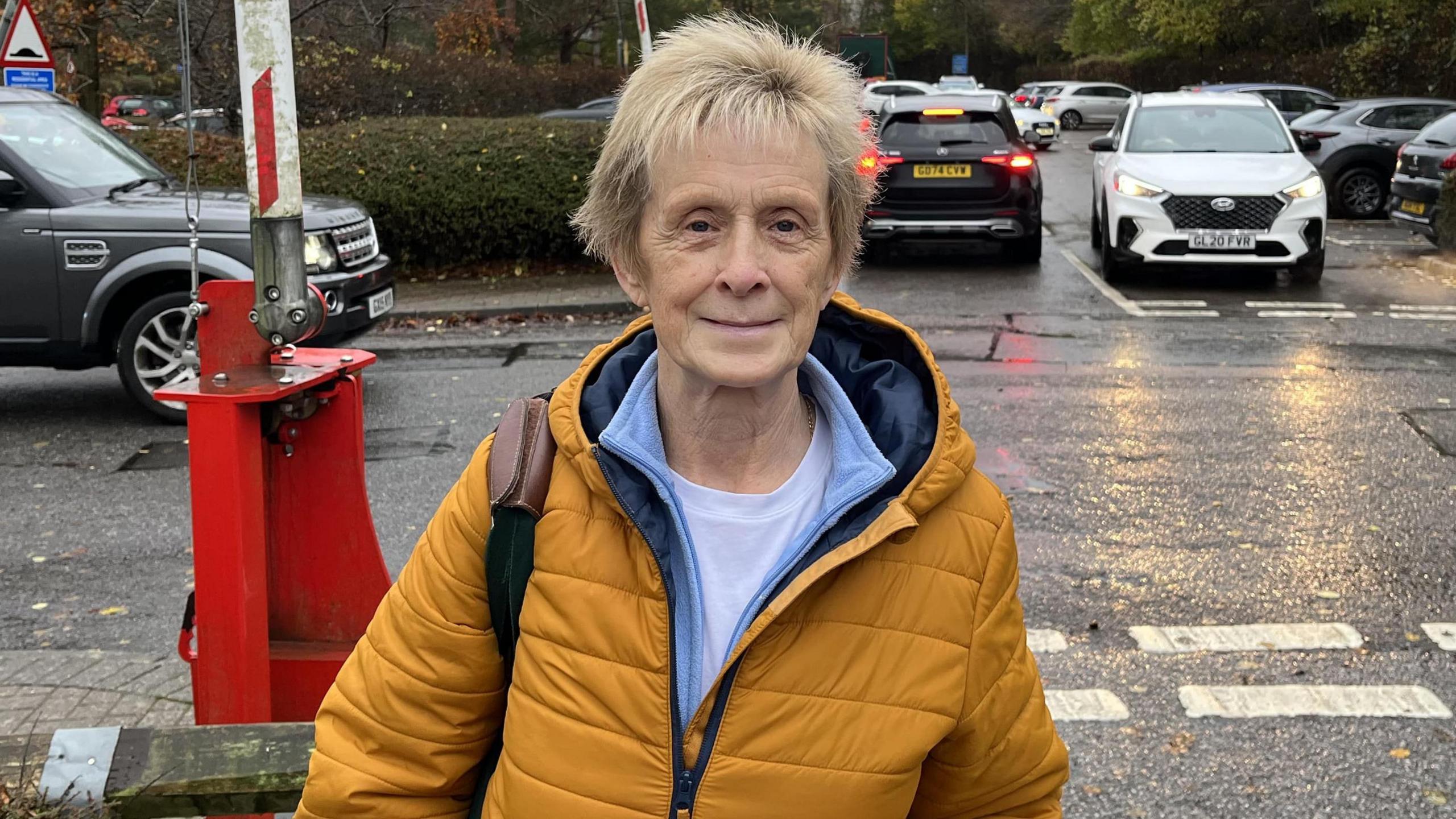 Older woman in  coat standing on road