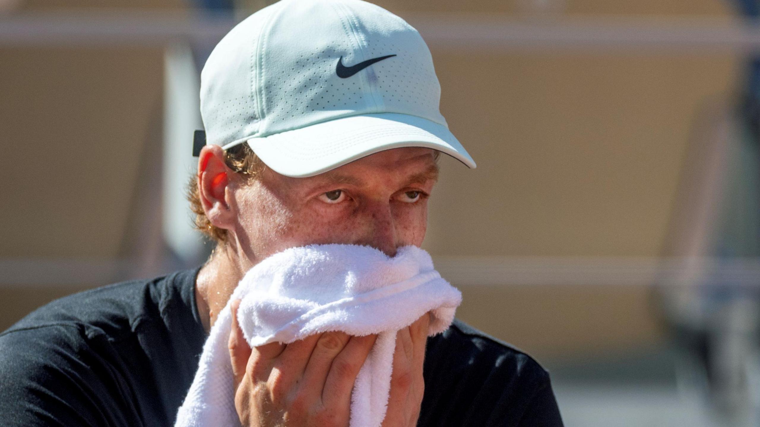 Jannik Sinner wipes his face with a towel during French Open practice