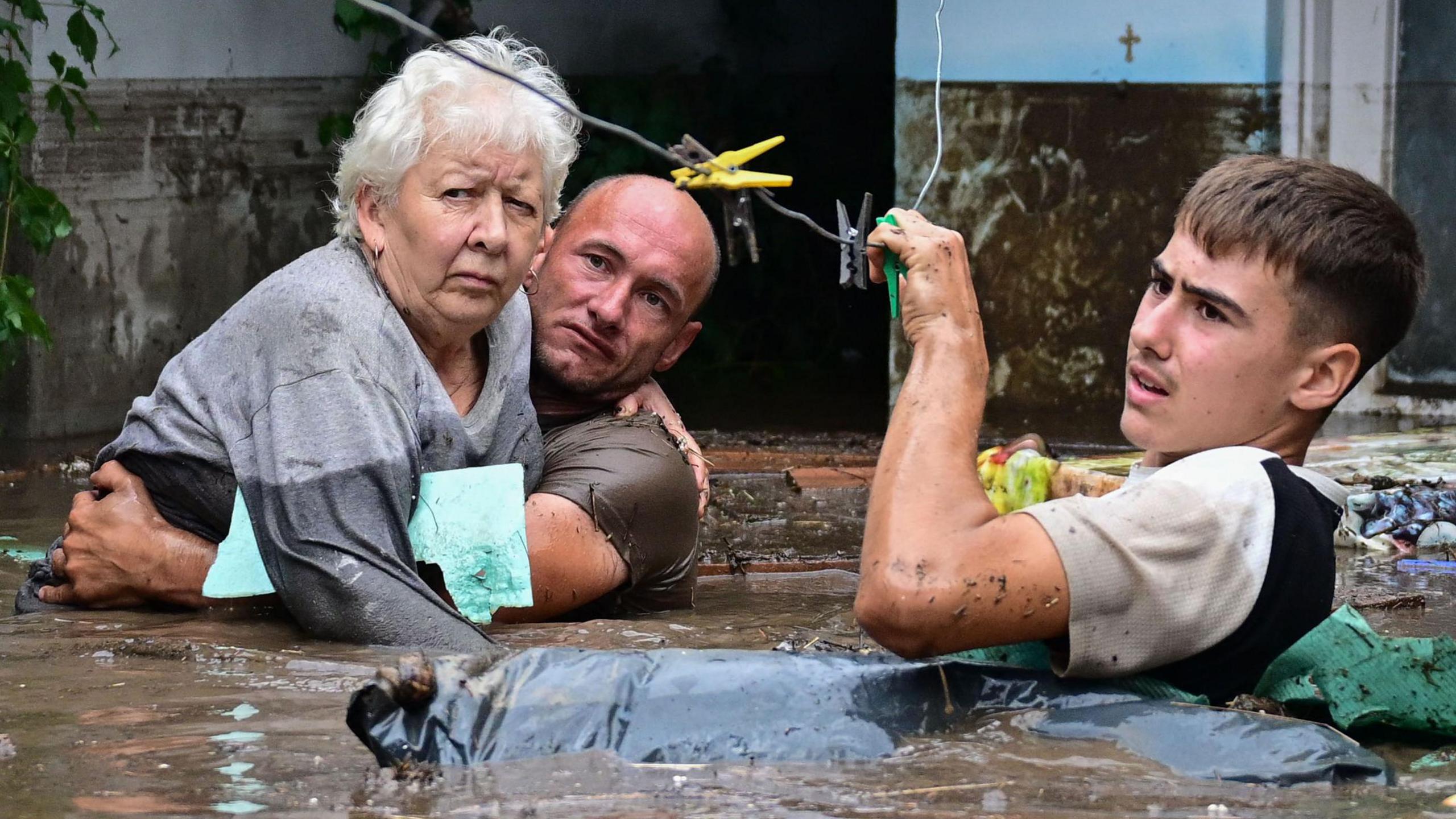 two men rescuing a woman