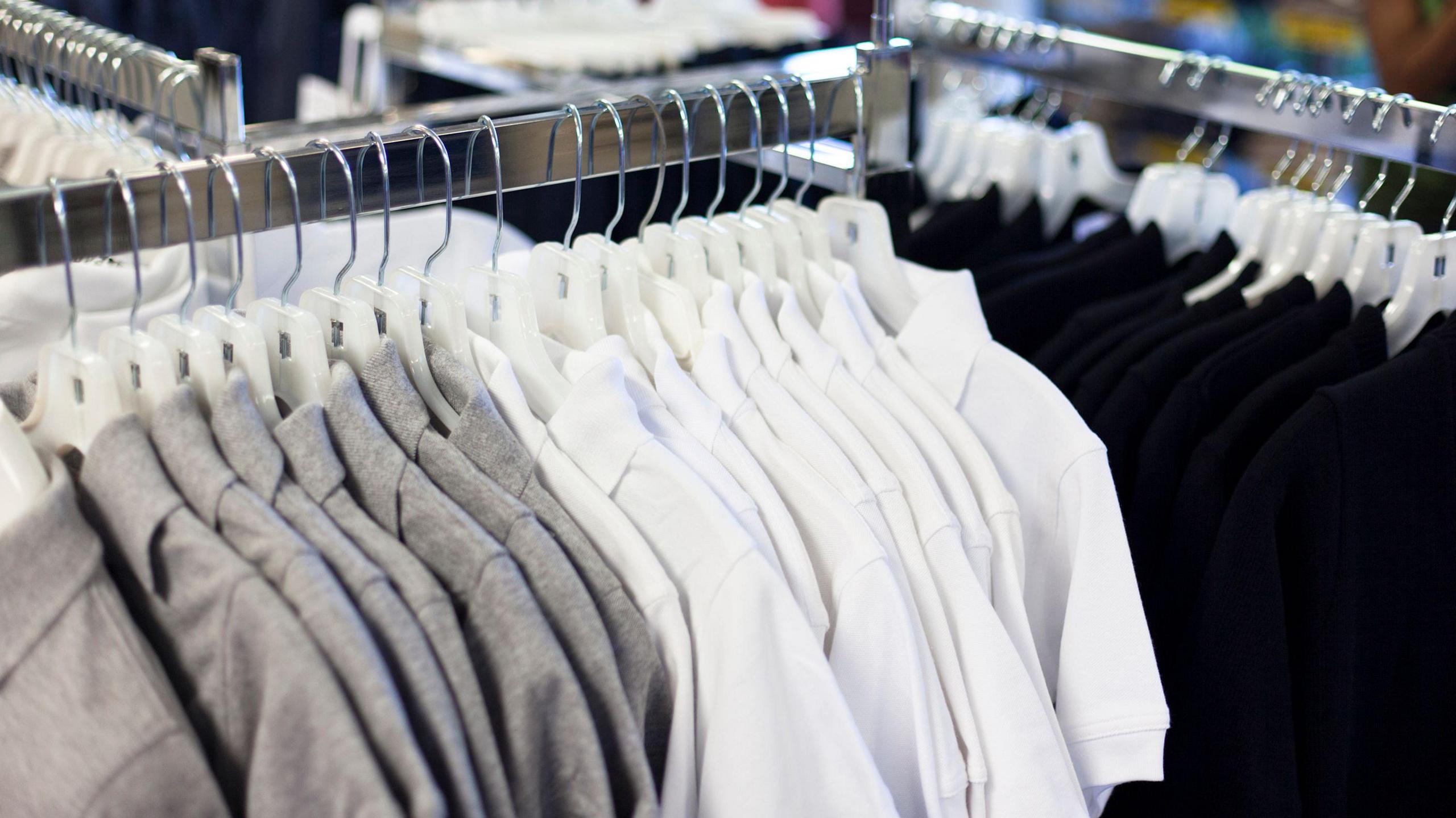 A rack of miscellaneous coloured school uniform shirts.