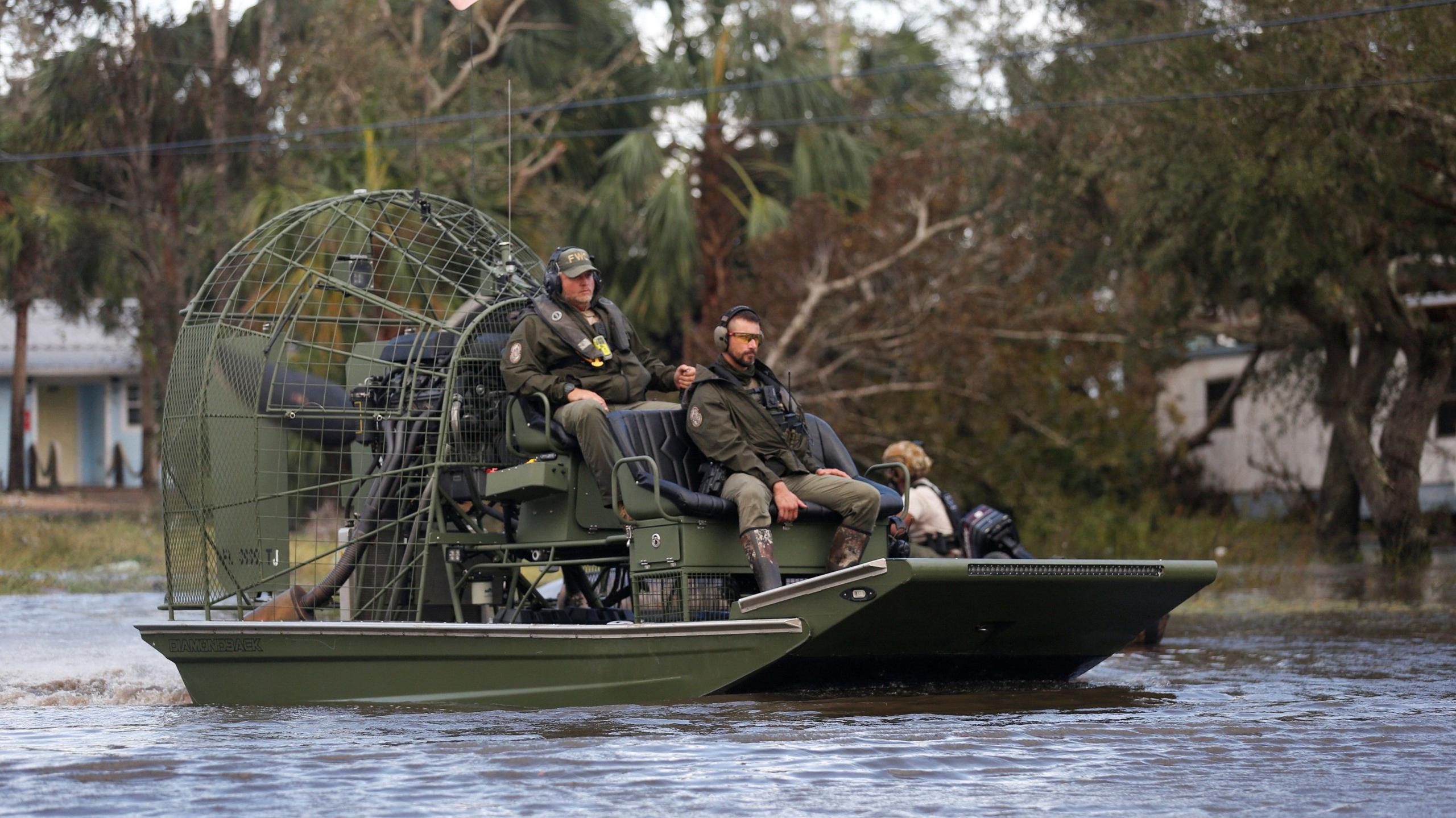 Florida Fish and Wildlife Conservation Commission officers sit on an airboat in water