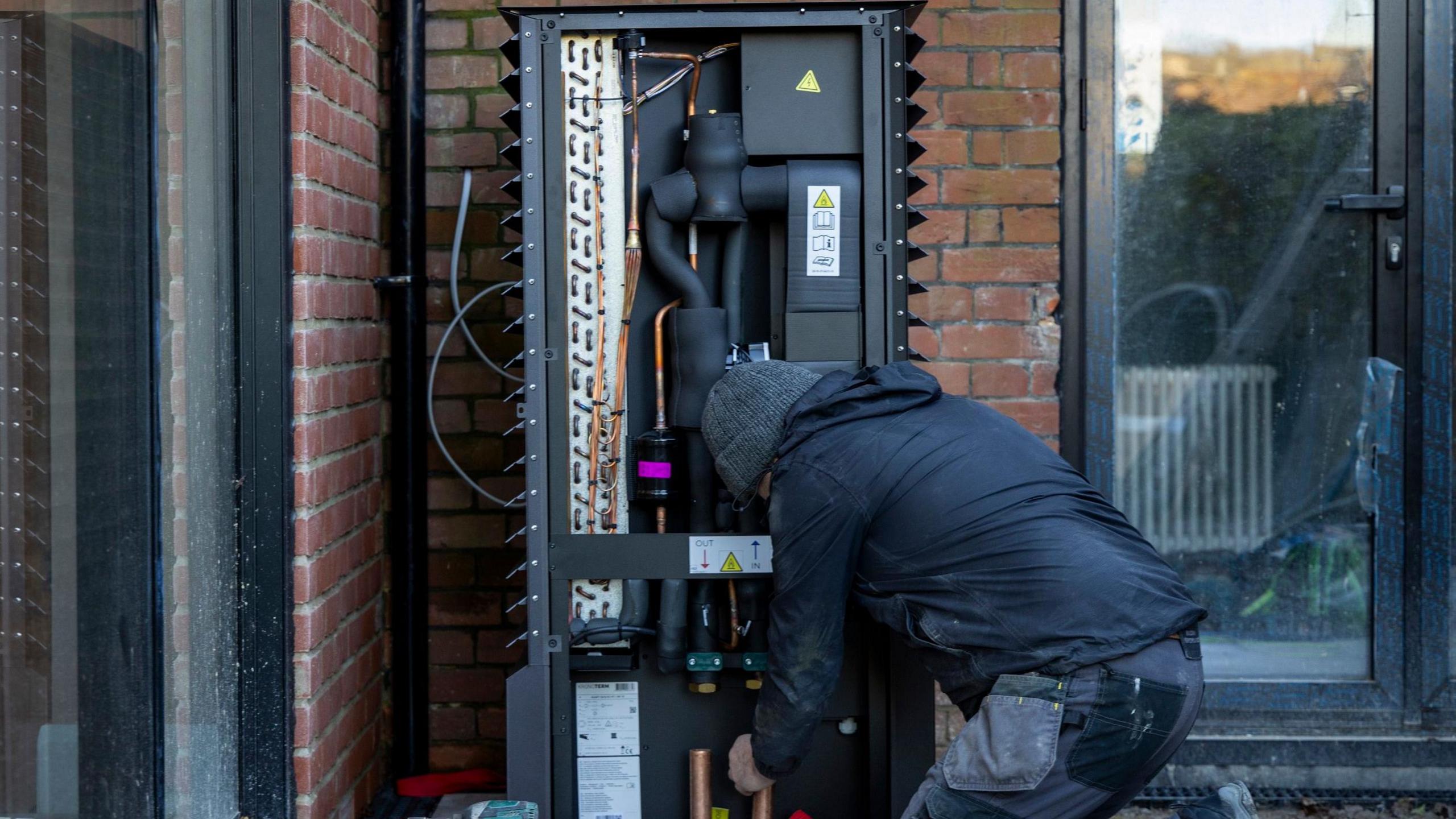 Air source heat pump being installed into a 1930's built house on the 29th of November 2024 near Ashford United Kingdom.