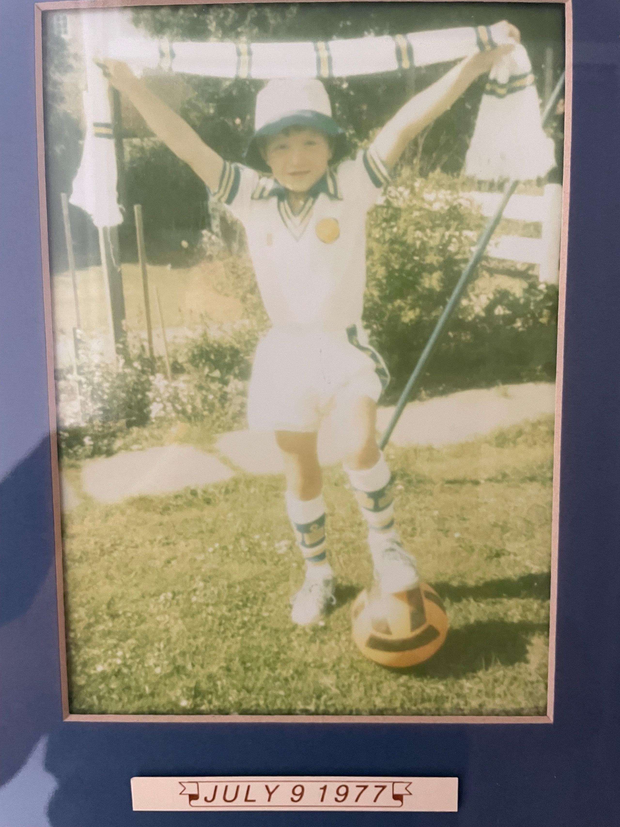 An image of a boy wearing a Leeds kit holding a scarf with the date July 9, 1977