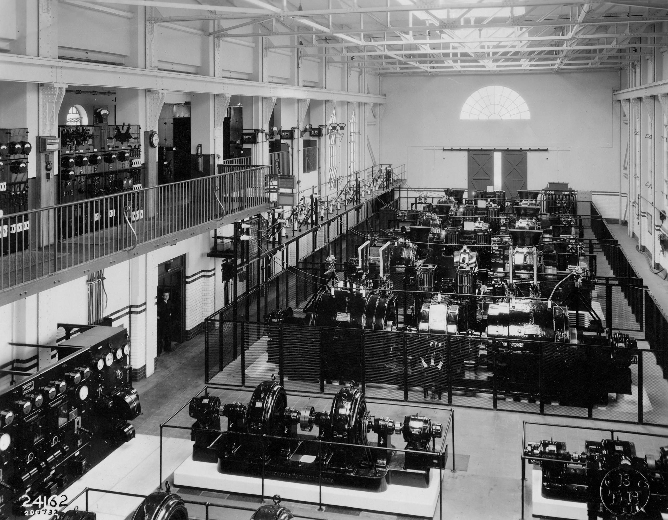 A huge hall houses radio telephony equipment on tables and fixed to the walls as well as on a balcony