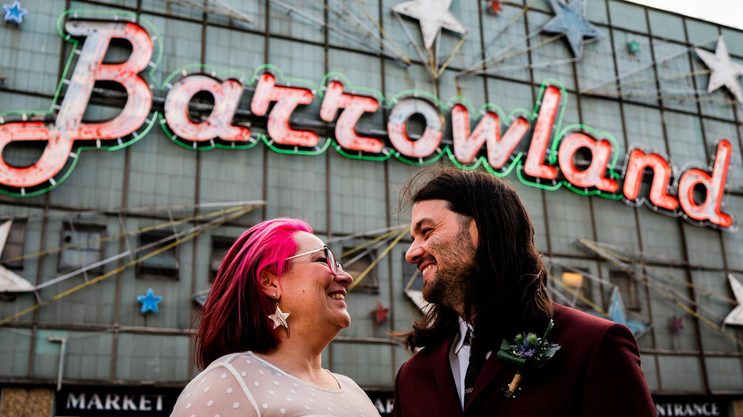 Bride and groom looking at each other with the Barrowland ballroom behind them