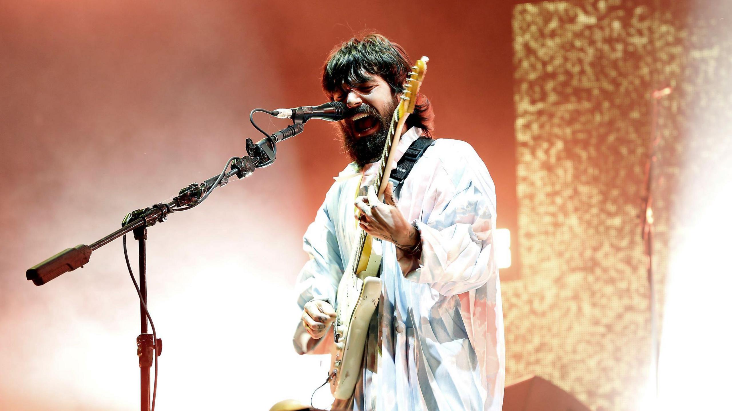 Biffy Clyro singer Simon Neil performs onstage, dressed in all white