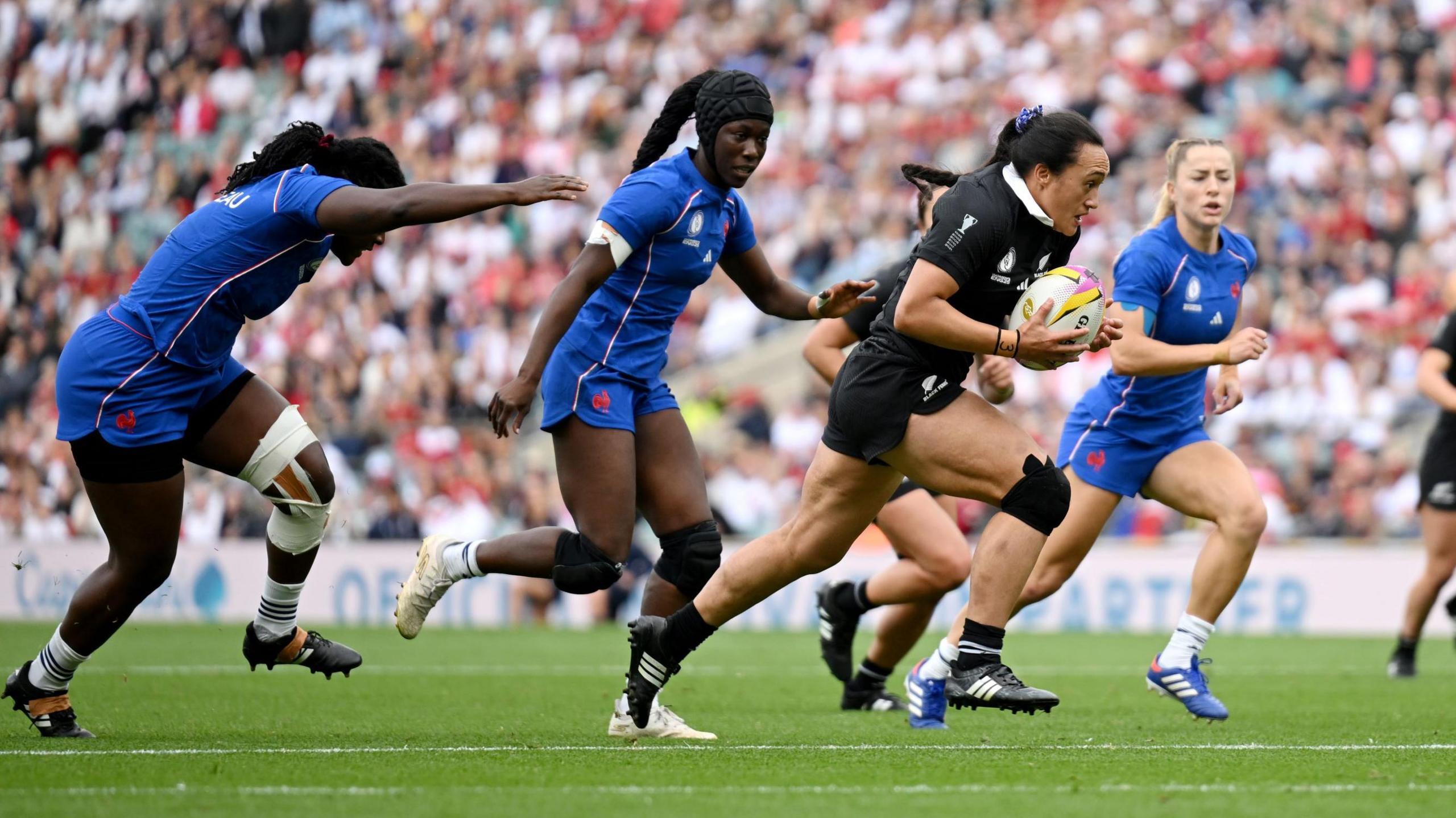 Ruahei Demant (second right) running with the ball in her hands during New Zealand's World Cup match against France 
