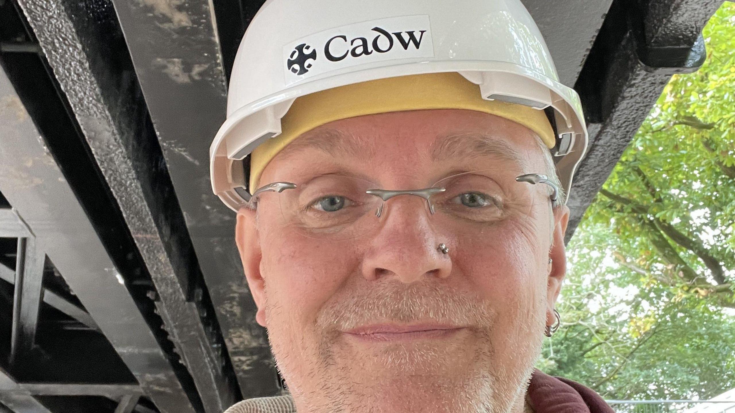 Jonathan Berry, senior inspector with Cadw, the Welsh government's archaeological service looks straight at the camera wearing a hard hat.