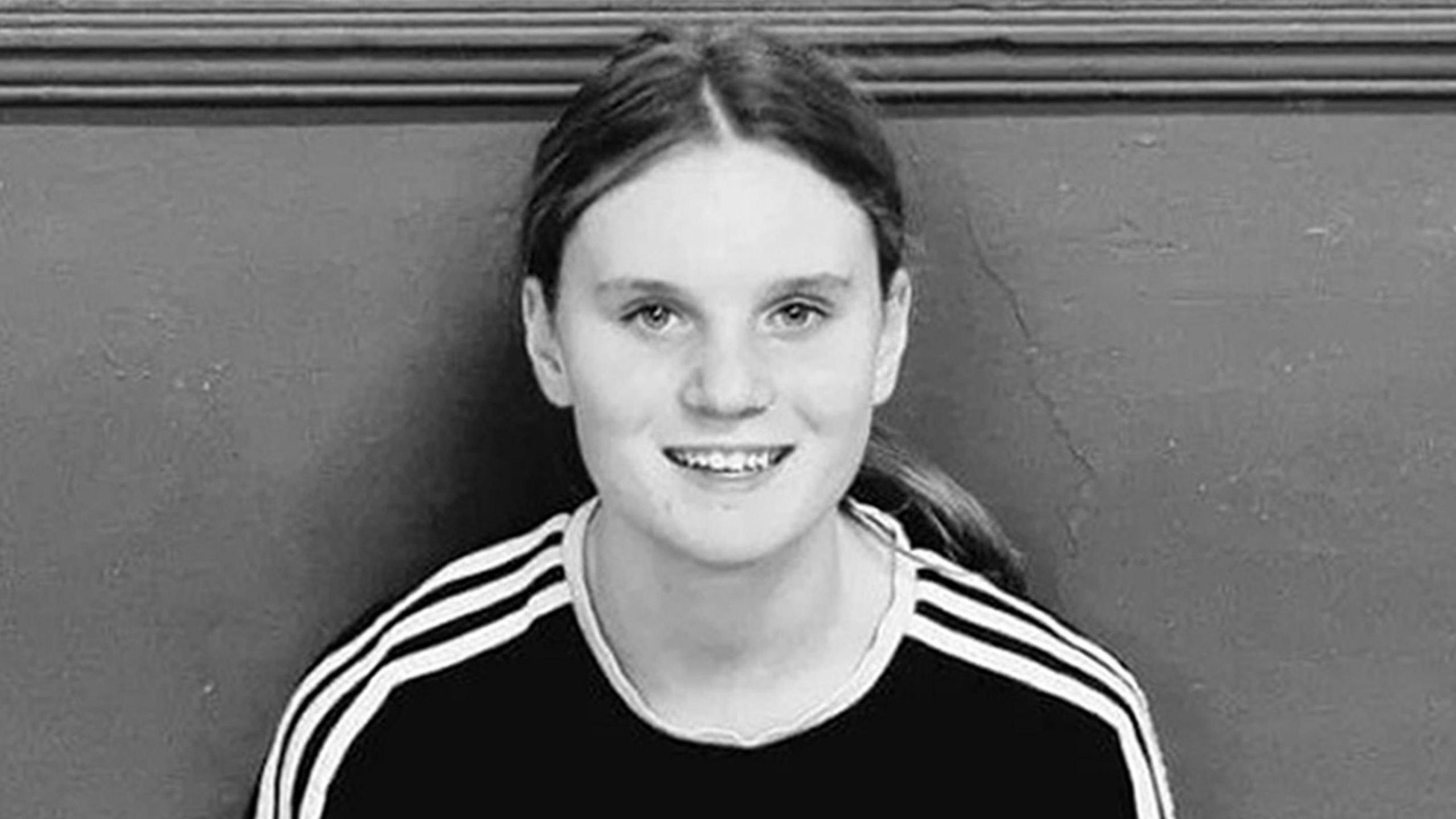 Black and white picture of a teenage girl with long hair in a pony tail