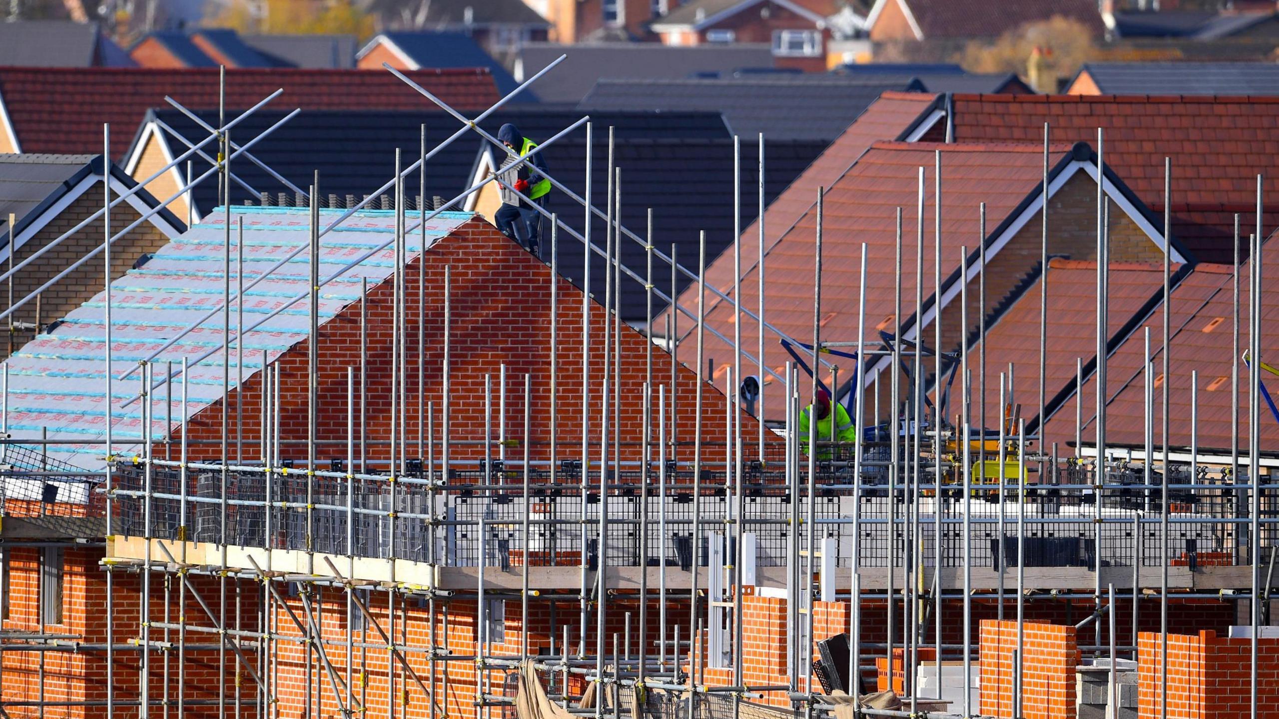 A view of construction workers building new homes
