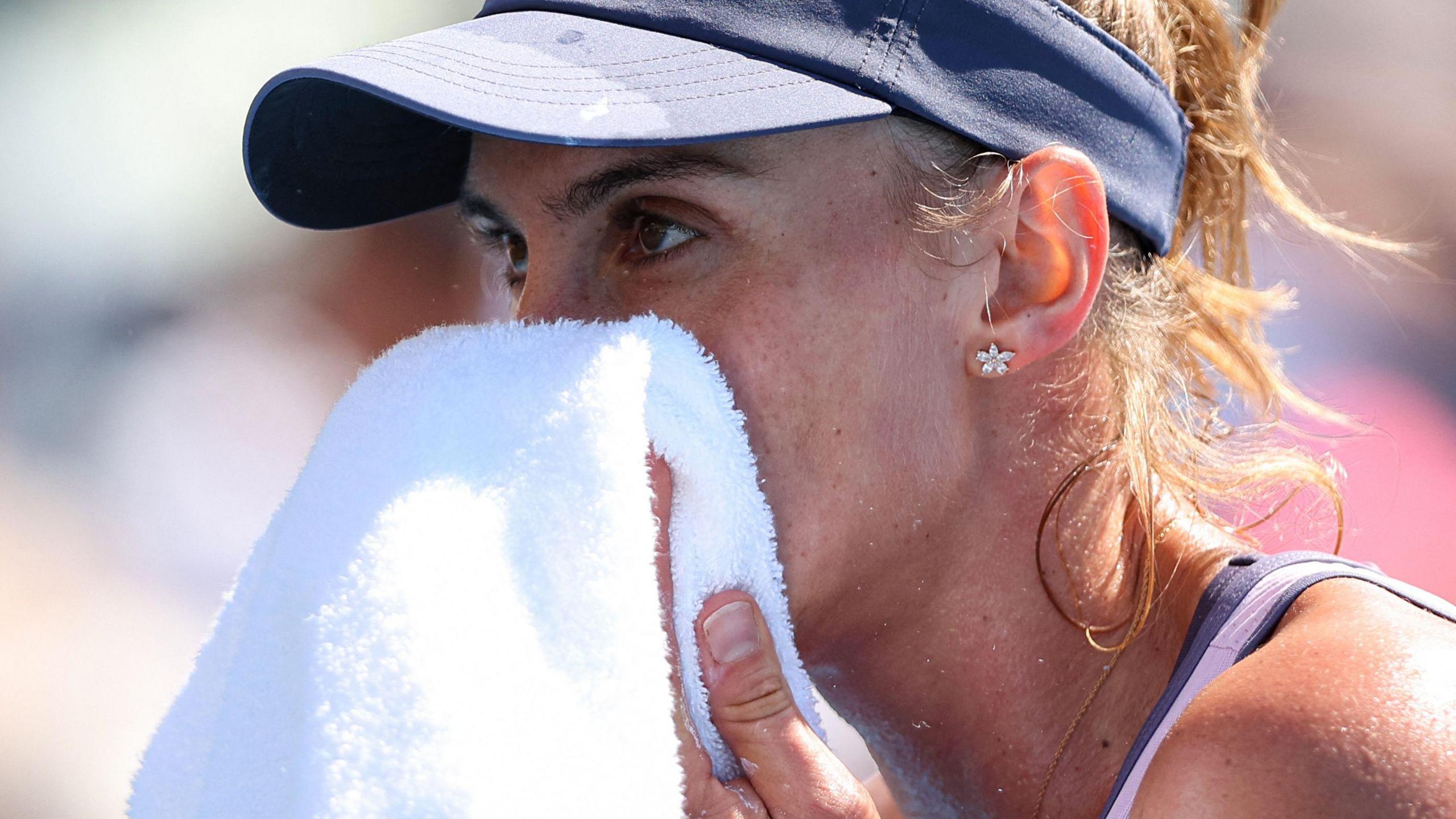 Brazil's Beatriz Haddad Maia wipes her face with a towel during a singles match at the 2025 Australian Open