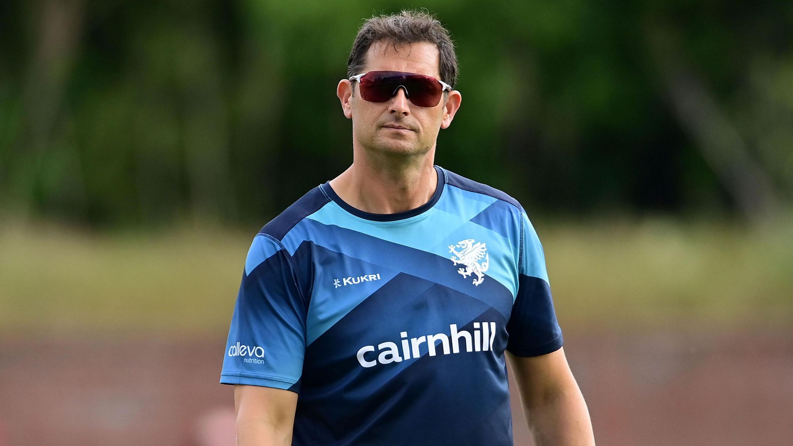 Jason Kerr wearing sunglasses and standing at the County Ground during a match this season