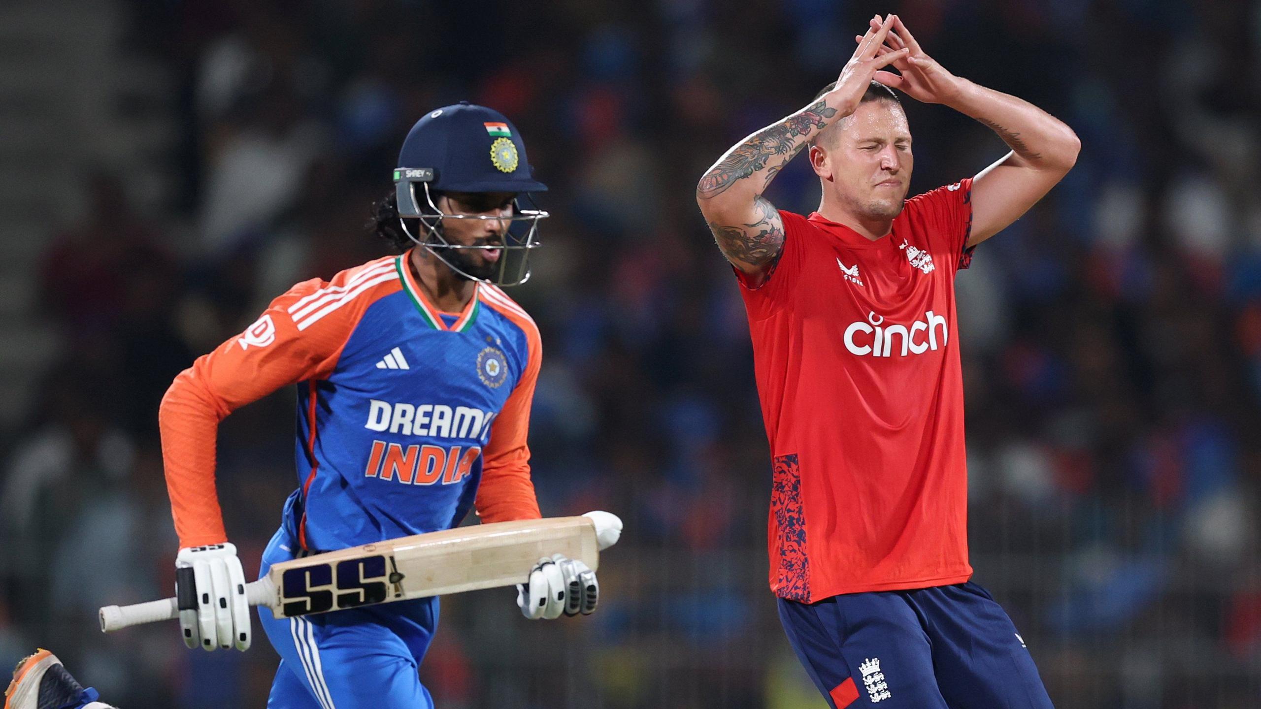 India batter Tilak Varma (left) runs past England bowler Brydon Carse (right), who throws his hands up in frustration