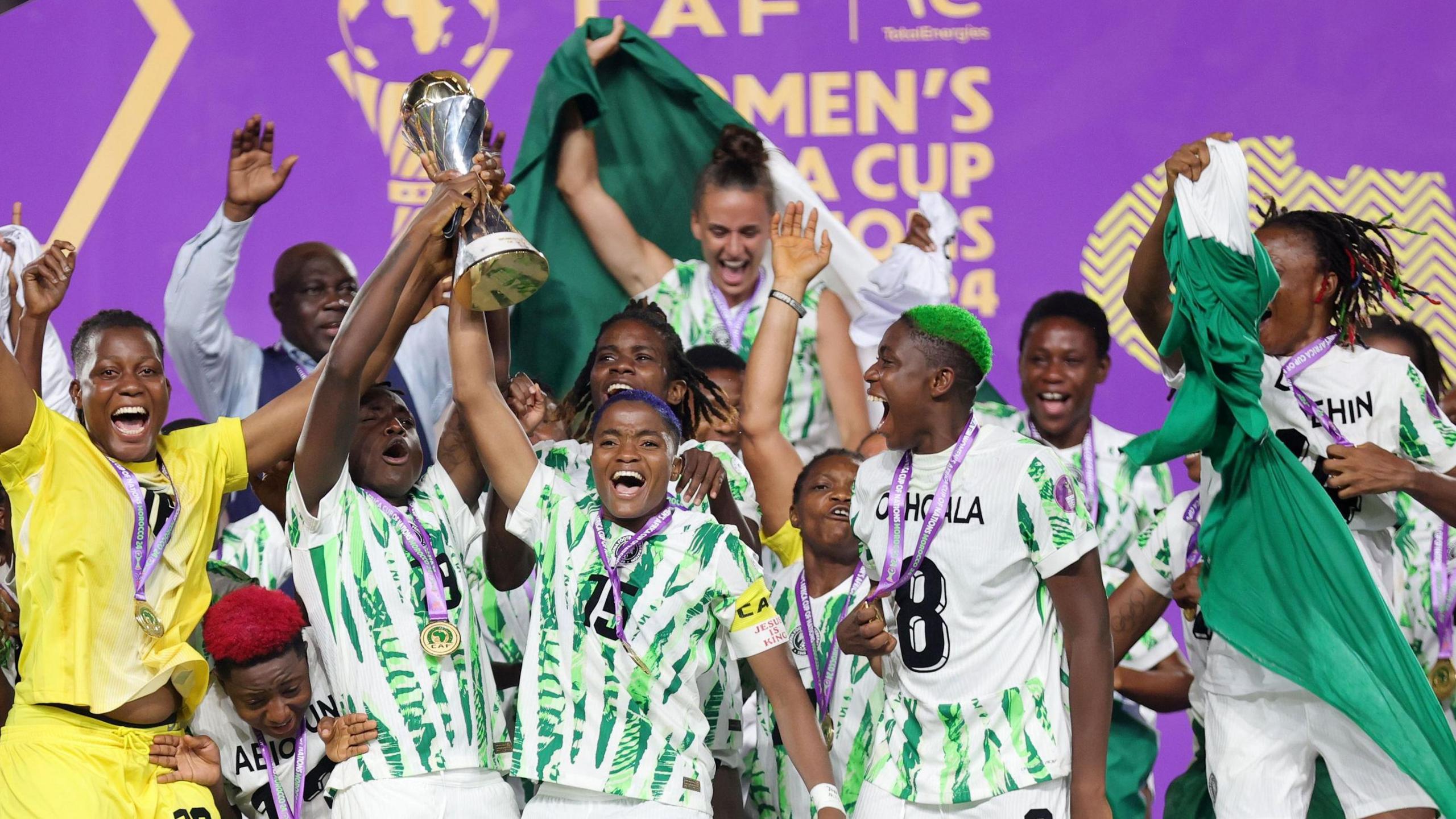 Nigeria's players celebrate with the Wafcon 2024 trophy, with captain Rasheedat Ajibade front and centre lifting it up above her head with her right hand