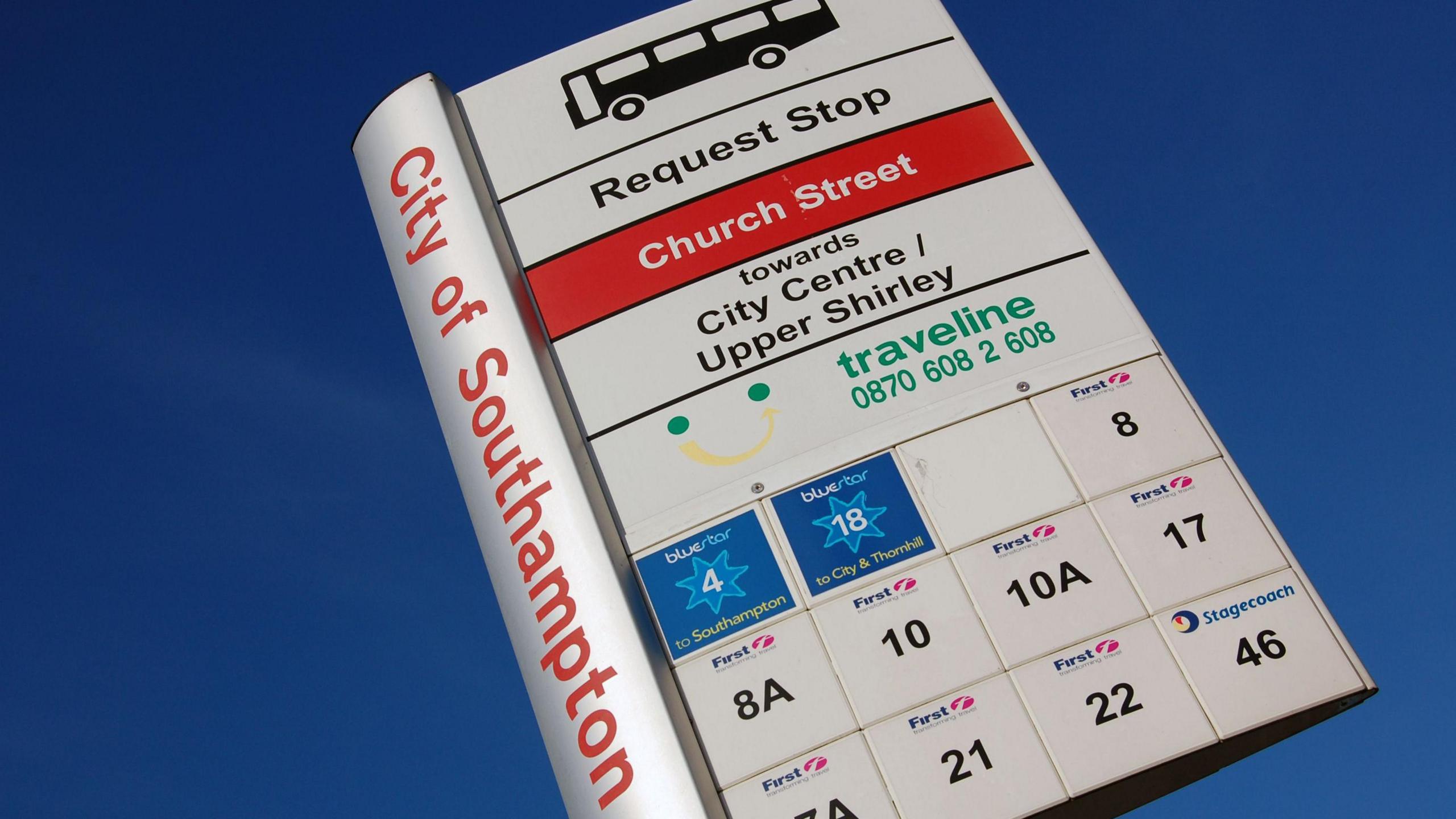 A bus stop sign in the Shirley area of Southampton, with a bright blue sky behind it