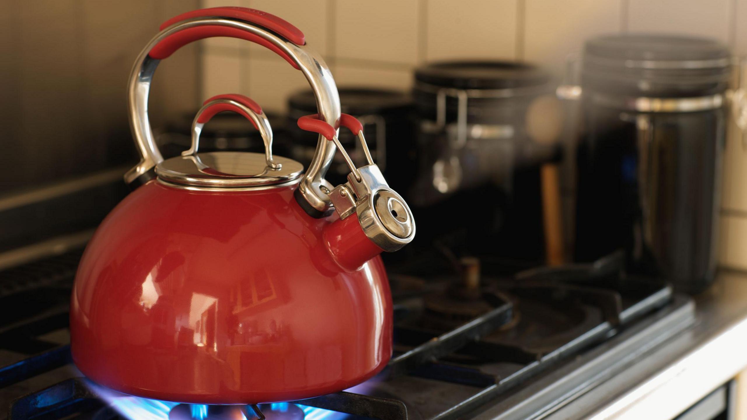 A kettle boiling water on a gas ring / gas cooker