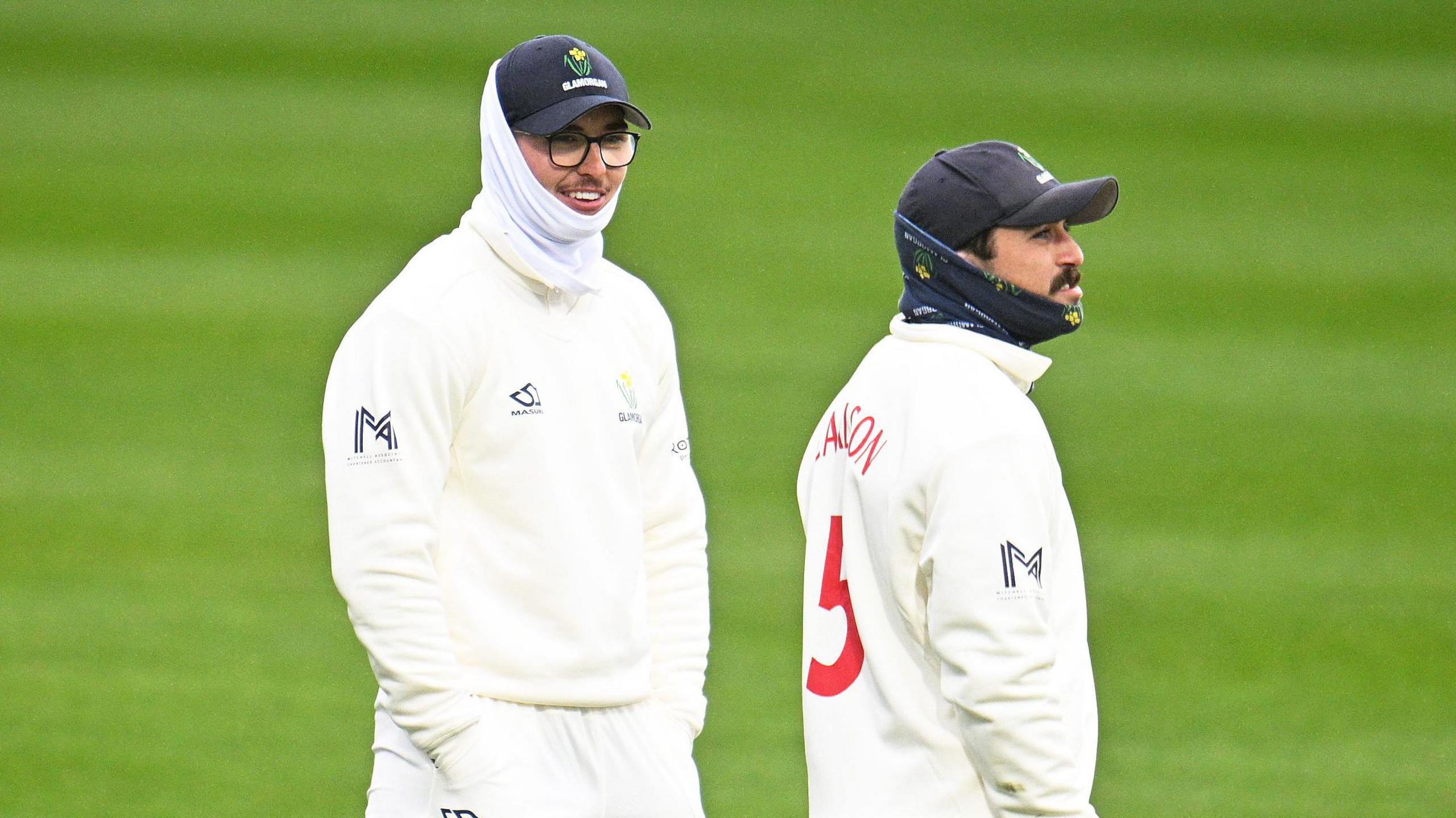 Glamorgan's Kiran Carlson and Asa Tribe during a pre-season fixture look ahead in full whites and snoods, they look very cold with their hands in their pockets 