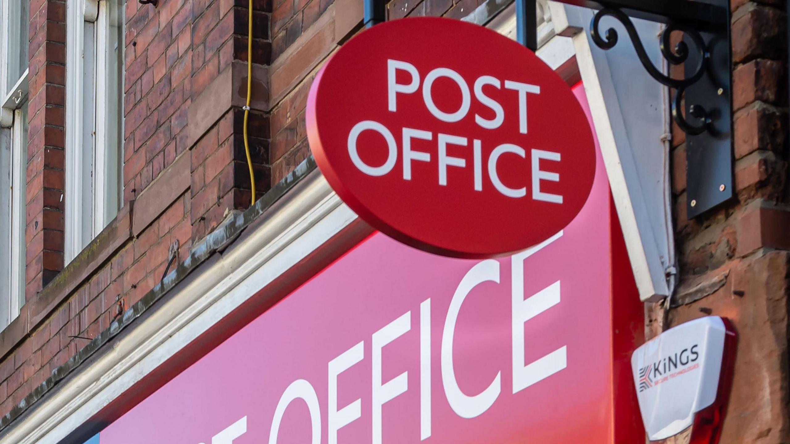 A red circular sign for the post office above a red horizontal sign also for the post office.