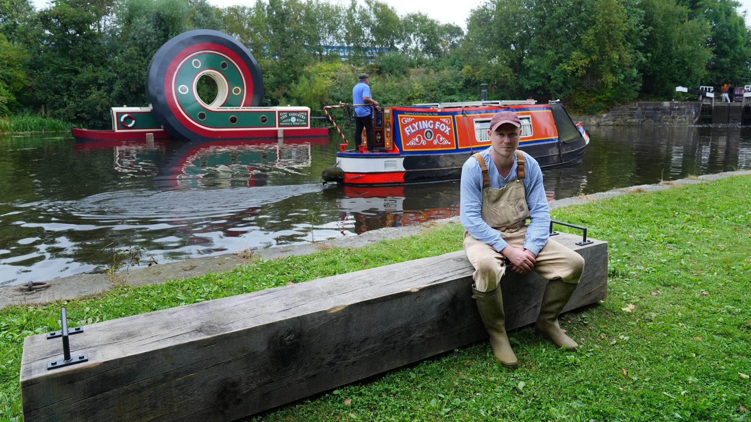 Artist Alex Chinneck with his sculpture of a canal boat after being installed on the Sheffield & Tinsley Canal