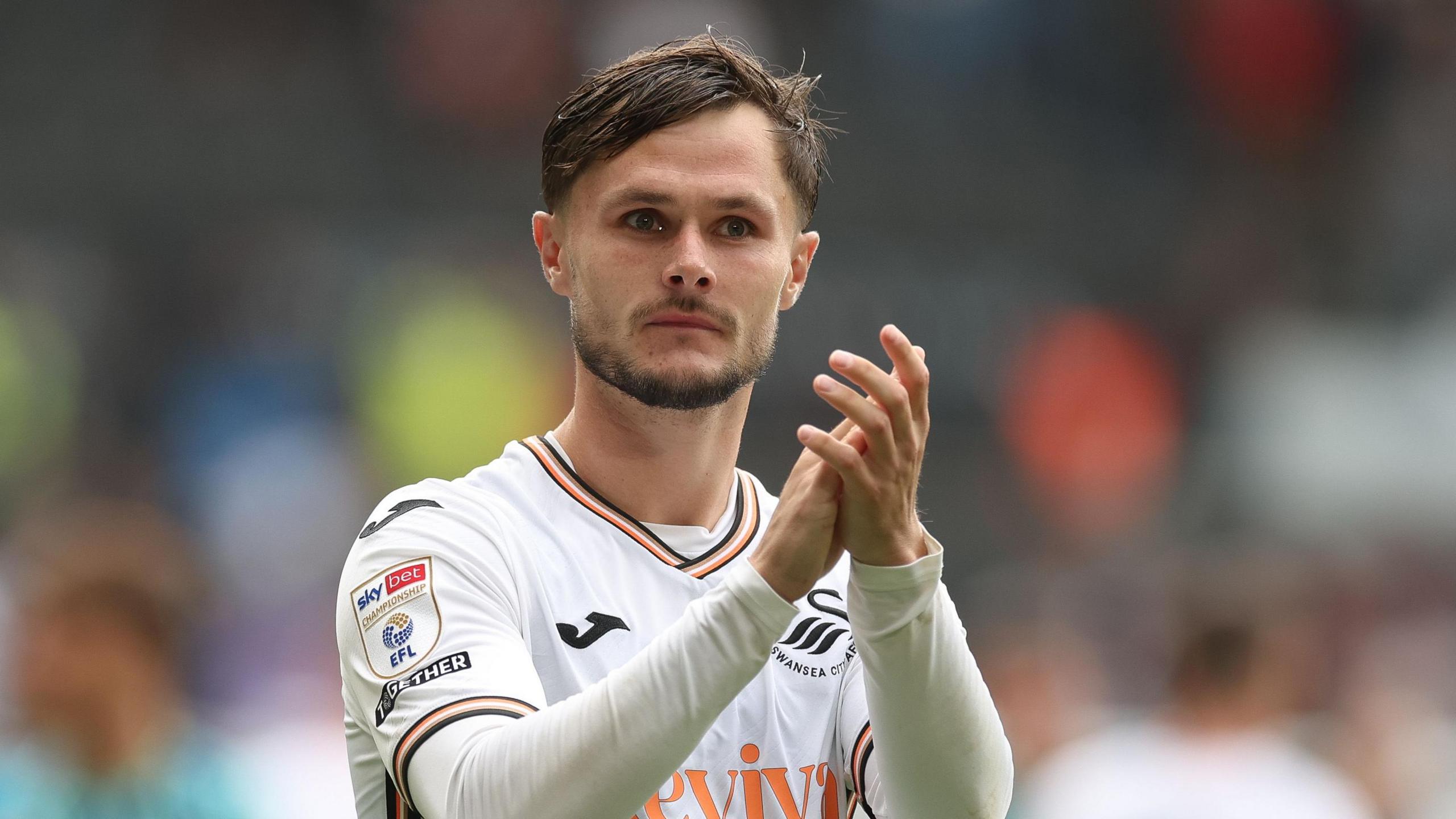 Liam Cullen applauds fans at a Swansea game