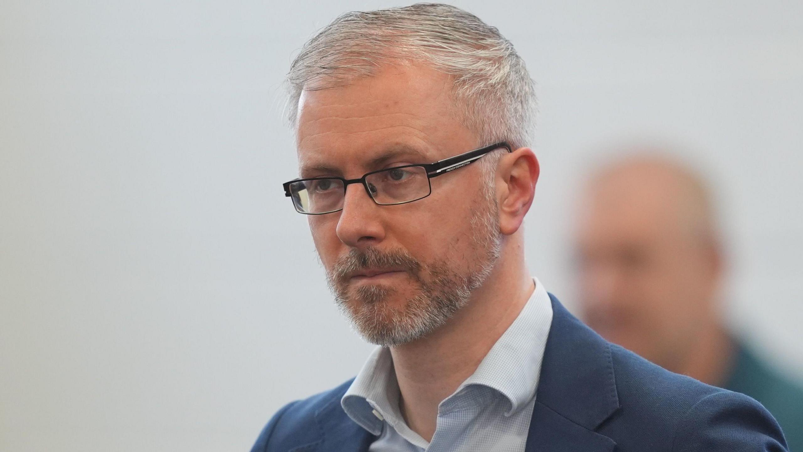 Green leader Roderick O'Gorman at an election count at Phibblestown Community Centre in Dublin.   He has short grey hair and a beard.  He is wearing black-rimmed glasses a blue shirt and a navy suit jacket.