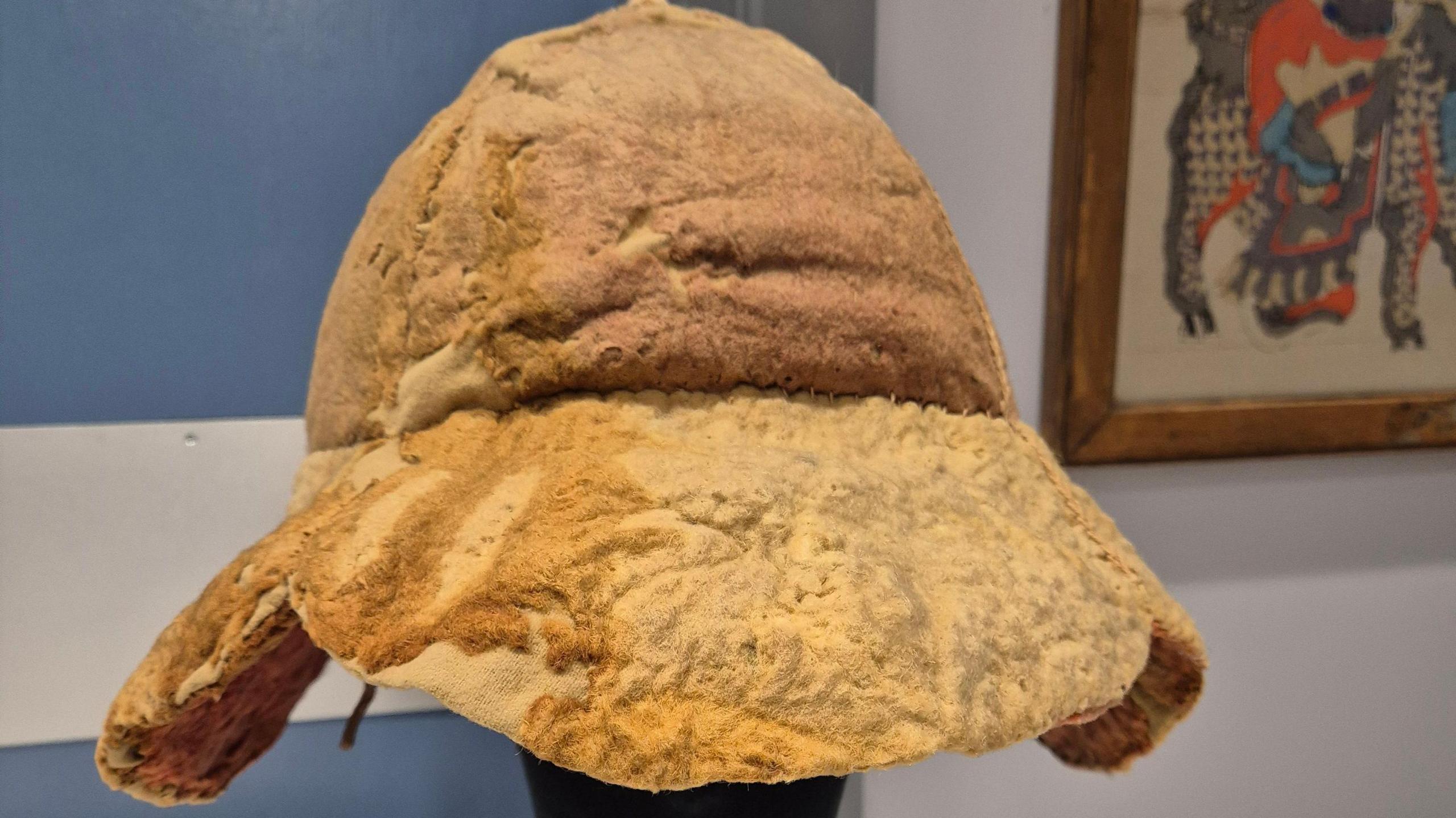The newly-conserved hat sits on a headrest.