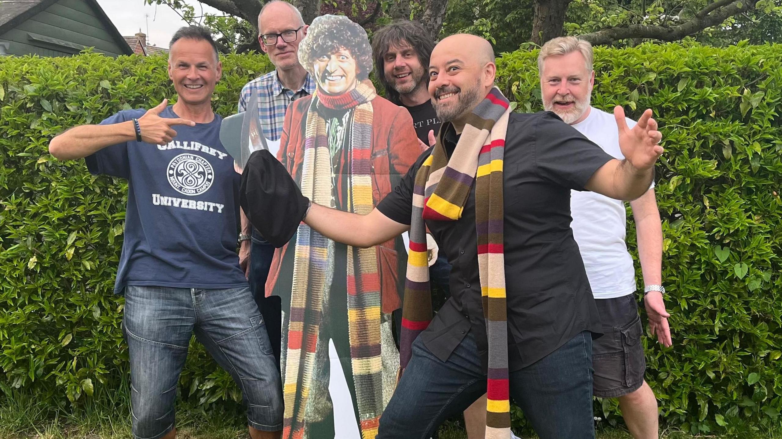 Lunar Kites pose for a picture with a Tom Baker/Doctor Who cutout. Tim wears a t-shirt that says 'Gallifrey University'. Antonio wears a Doctor Who scarf.