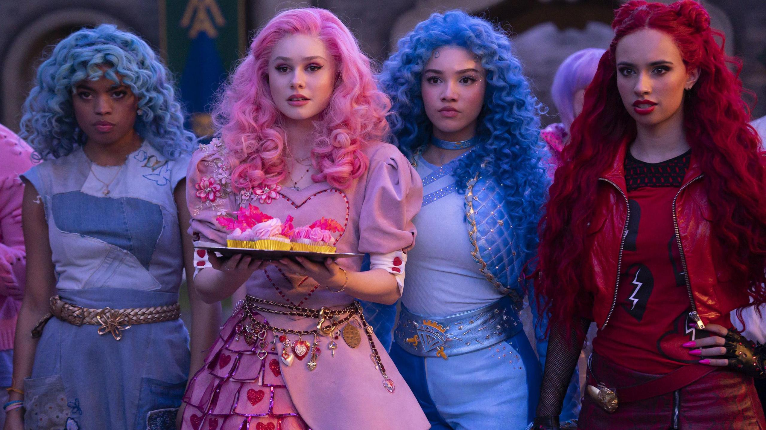 Four women, two dressed in blue and one dressed in pink and on dressed in red with blue pink and red hair