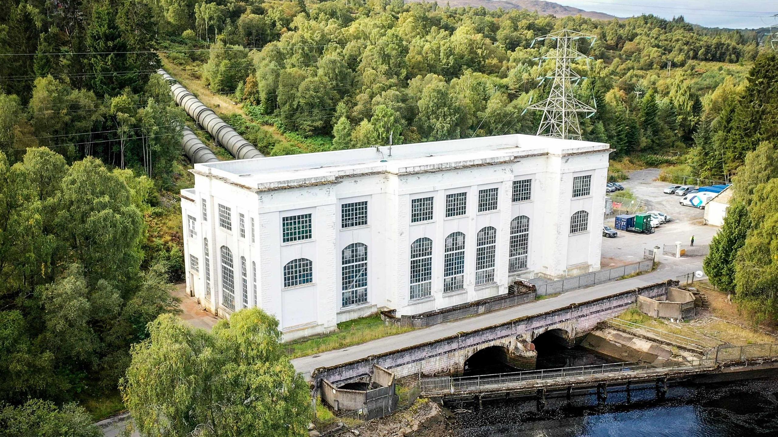 Tummel hydro power station is a rectangular building with large windows on the banks of a river