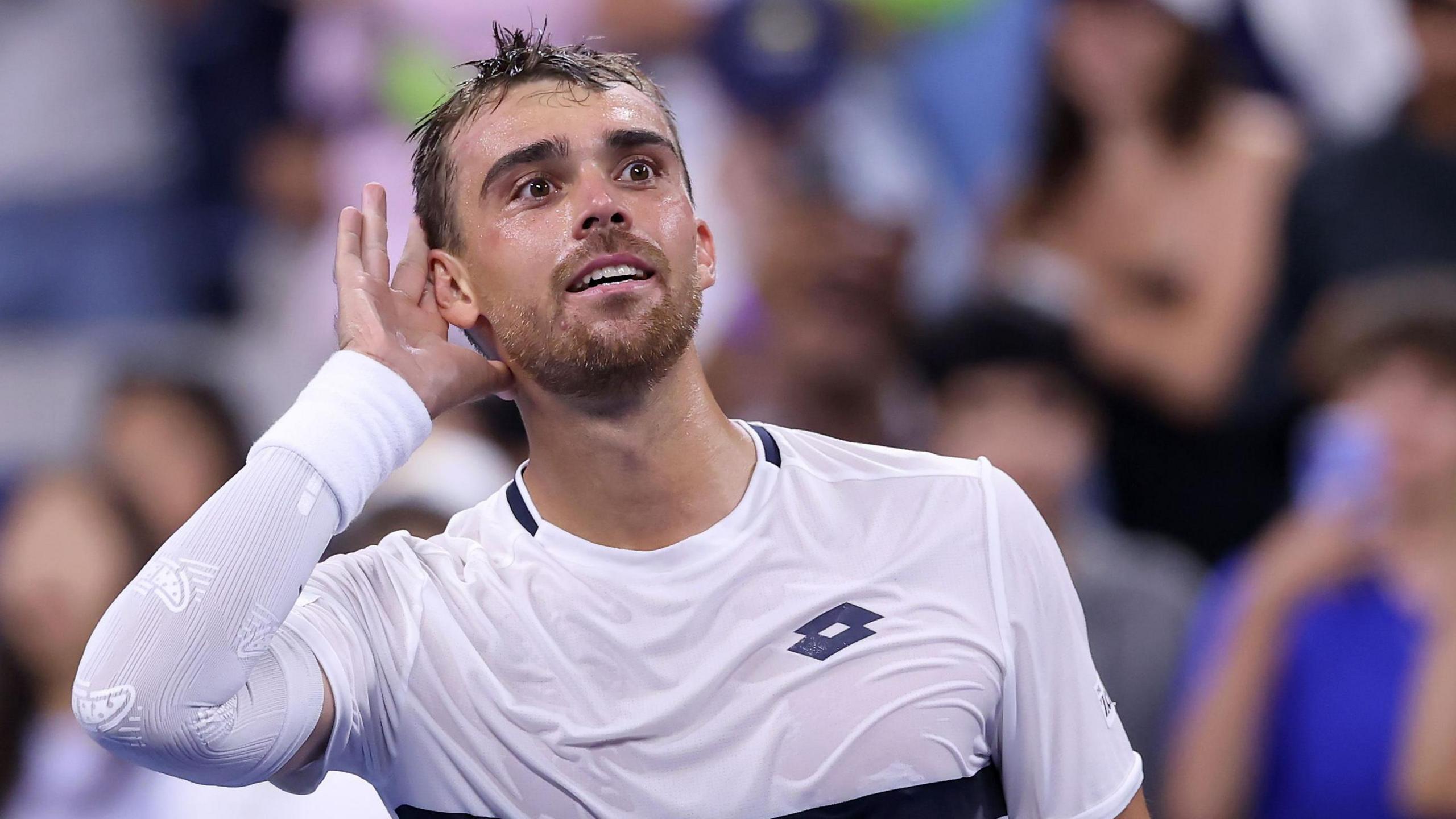 Benjamin Bonzi cups his ear to the US Open crowd after beating Daniil Medvedev