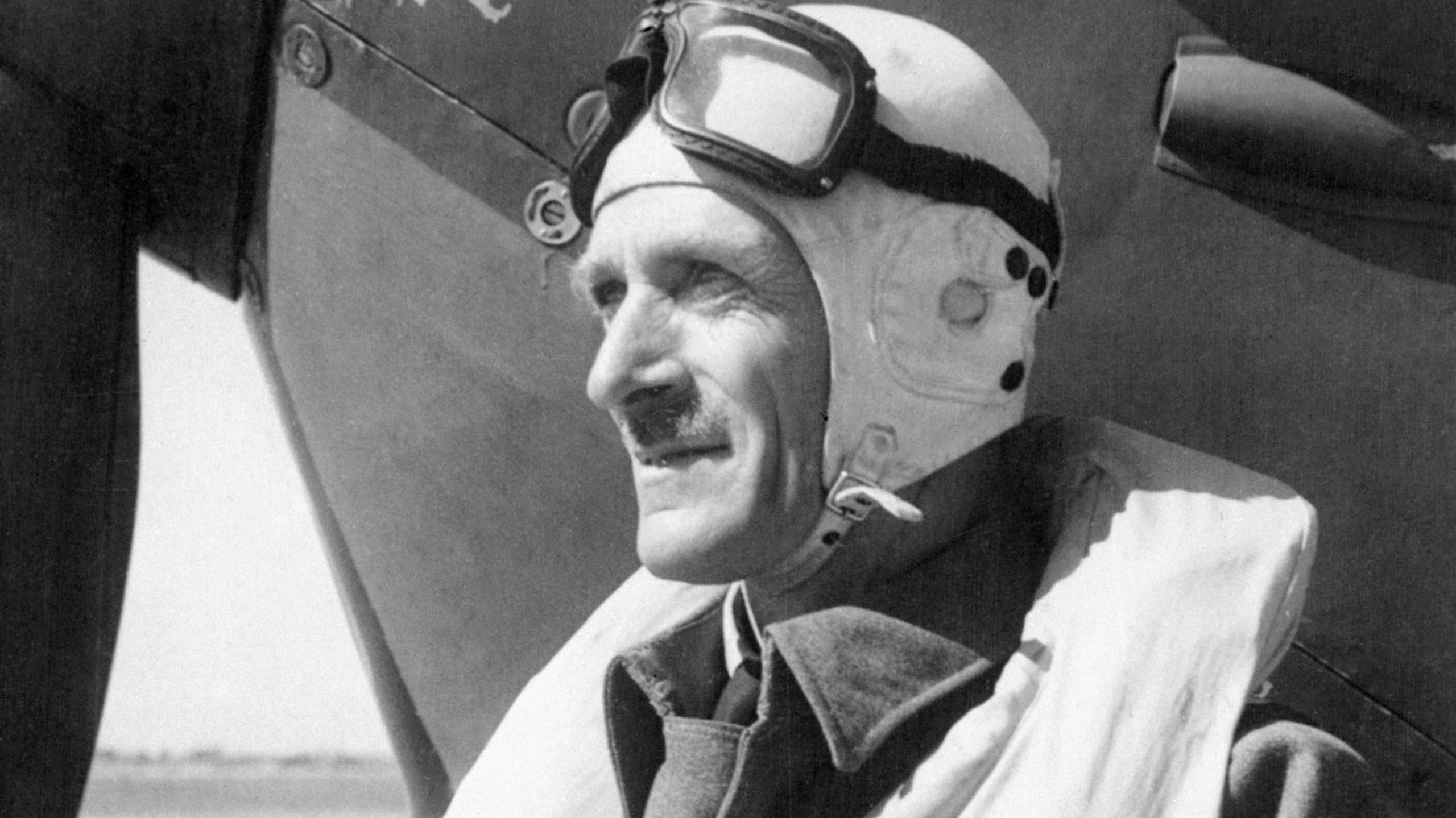 Air Vice Marshal Sir Keith Park, a New Zealander who was a principal Royal Air Force commander in the Battle of Britain and who later commanded the RAF in the Mediterranean, Italy and the Far East. Shown here preparing to fly his Spitfire in Malta, September 1942, wearing a flying helmet and life jacket over his army uniform. He is an older middle aged man with a moustache.