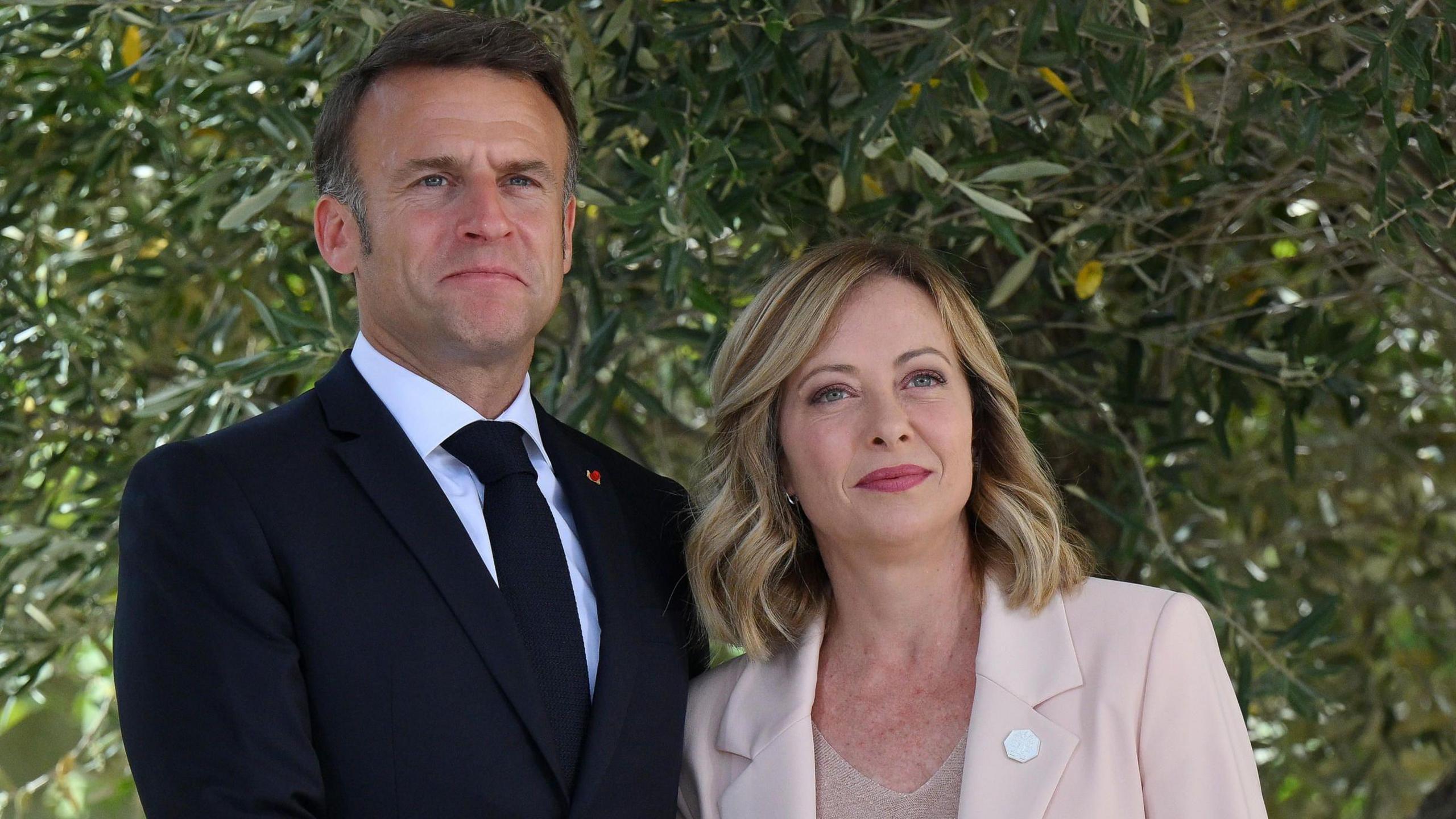 Italy's Prime Minister Giorgia Meloni  shakes hands with French President Emmanuel Macron