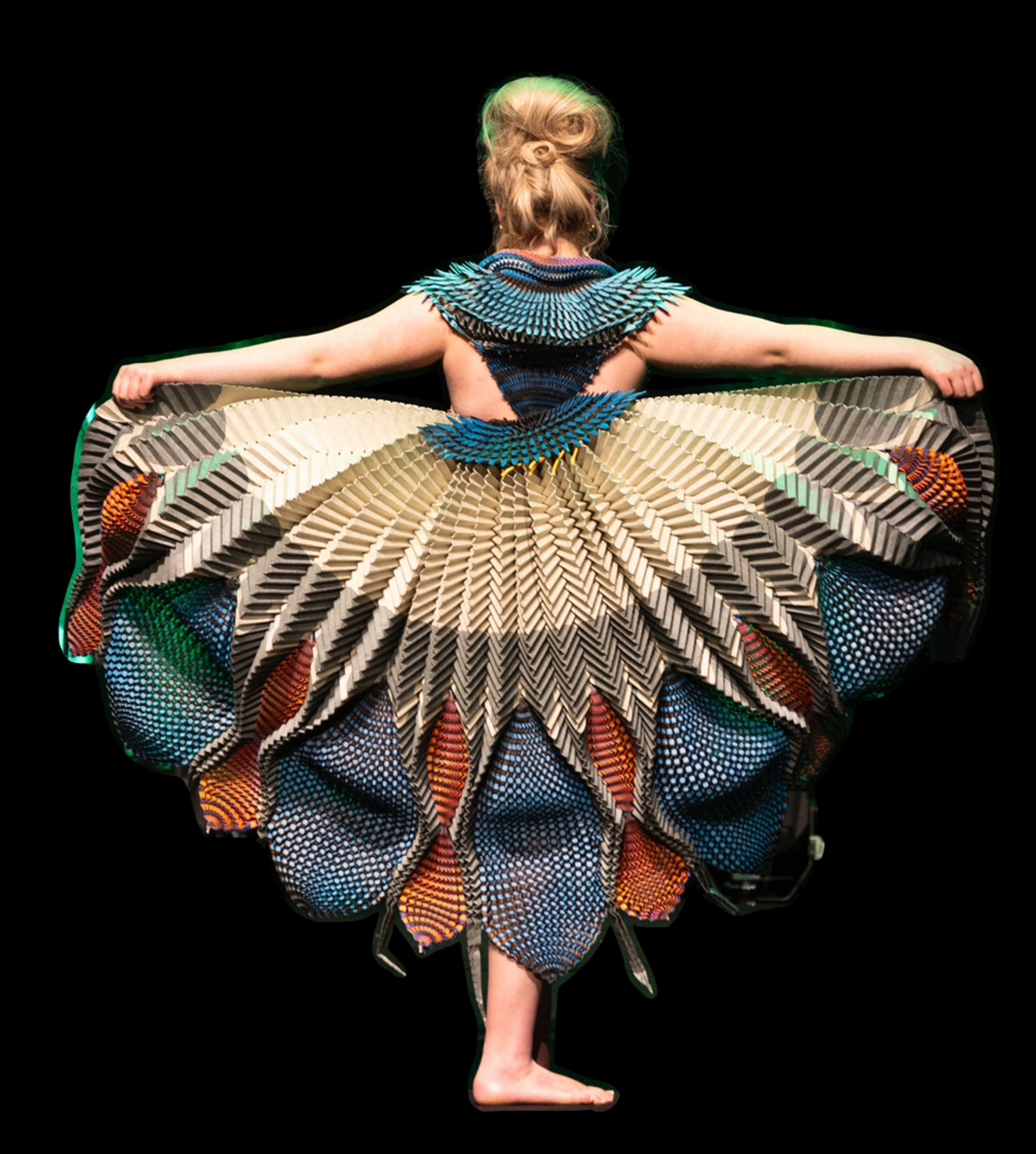 A woman wearing a dress created from paper art. 