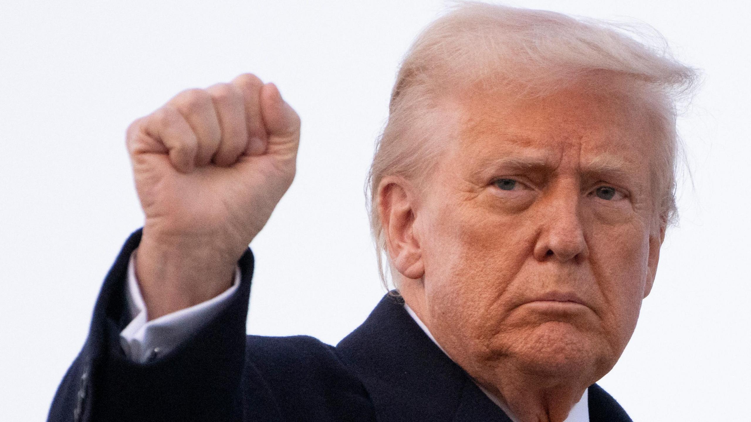 US President Donald Trump pumps his fist as he boards Air Force One at Joint Base Andrews in Maryland on March 7, 2025.