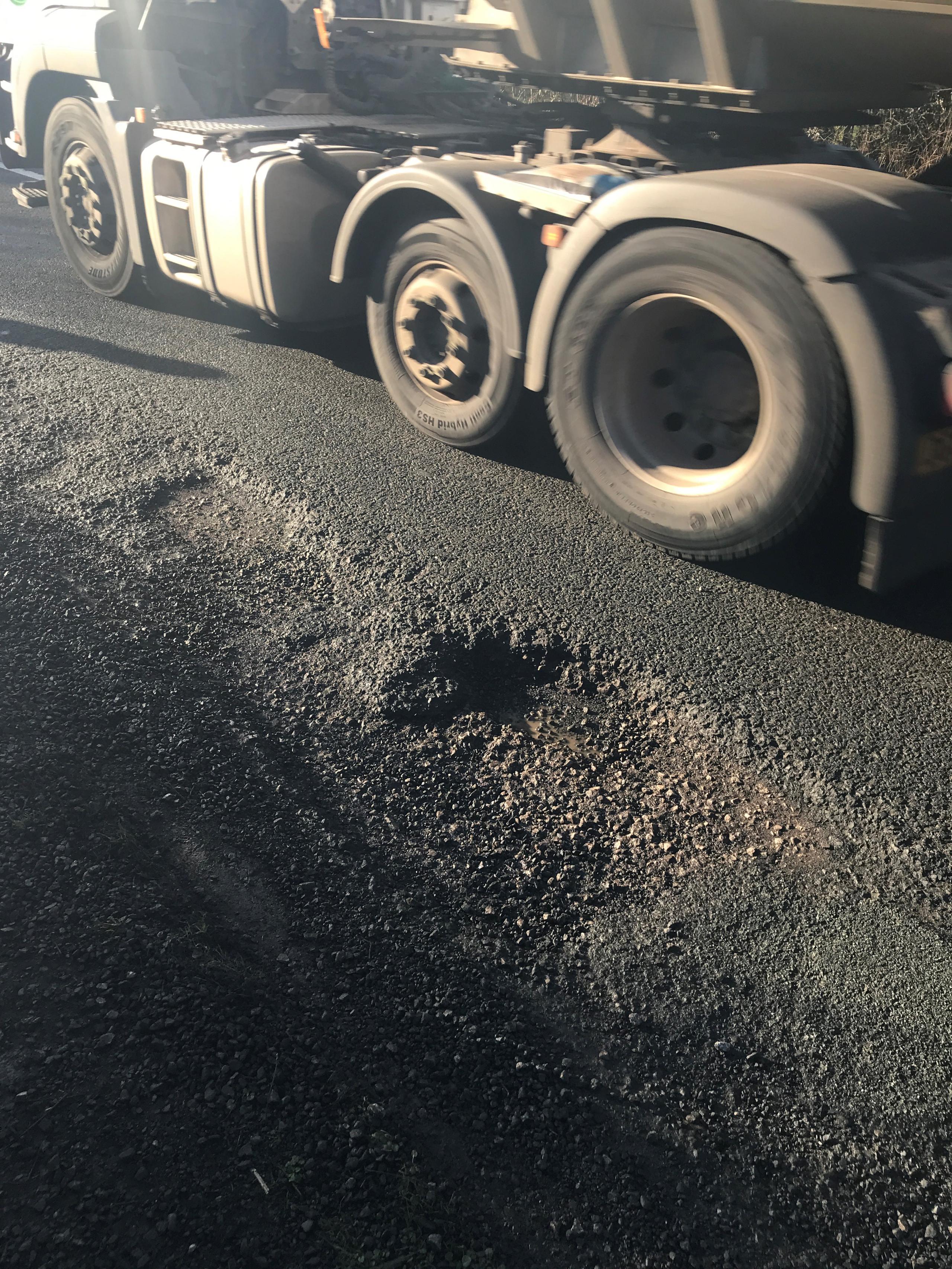 Pothole near lorry